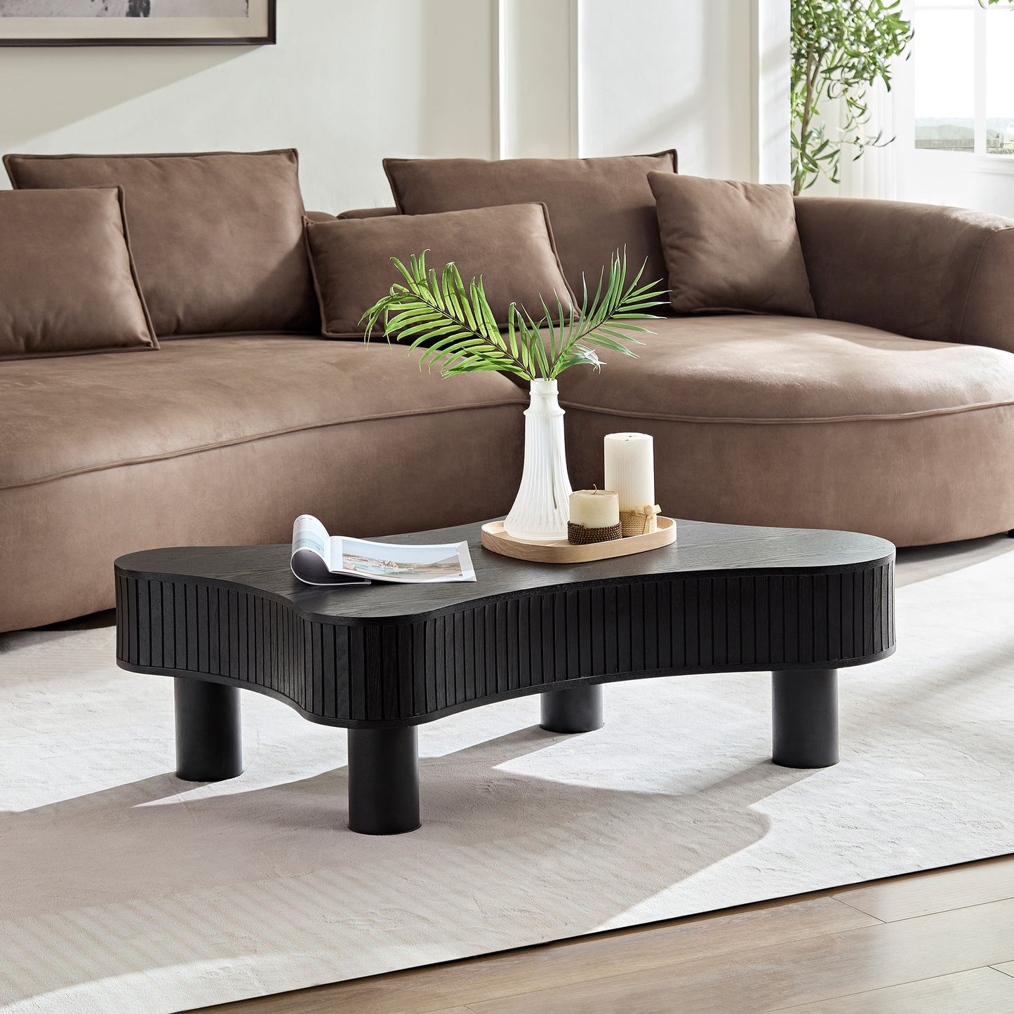 Black wooden wavy coffee table with ribbed detailing and black cylindrical legs