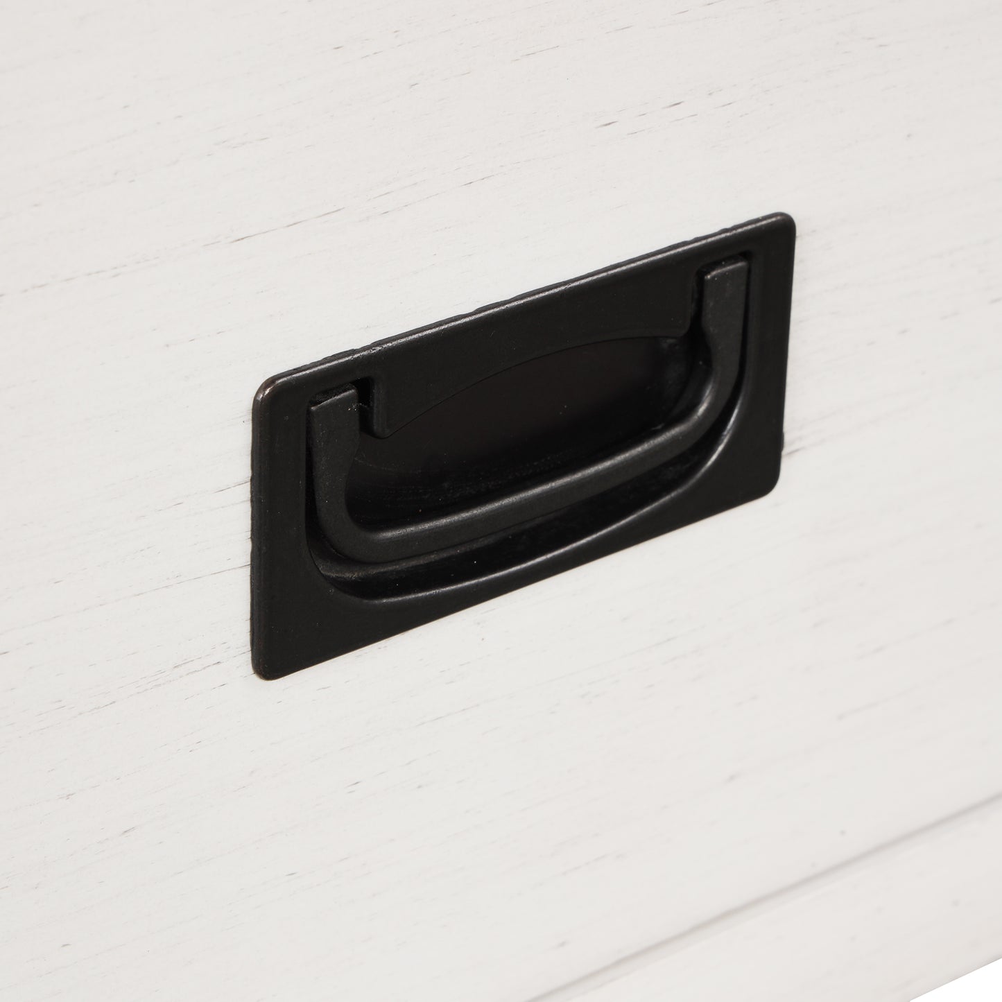 Closeup of a white distressed wood drawer with a black iron pull handle