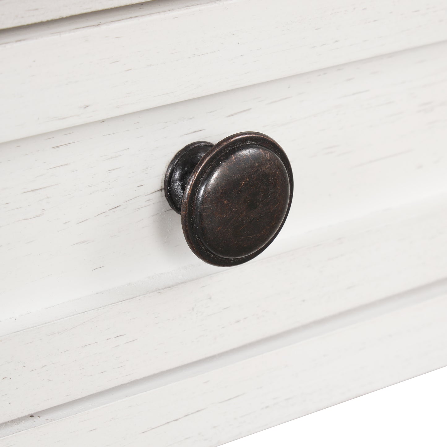Closeup of antique bronze drawer knob on distressed white dresser drawer