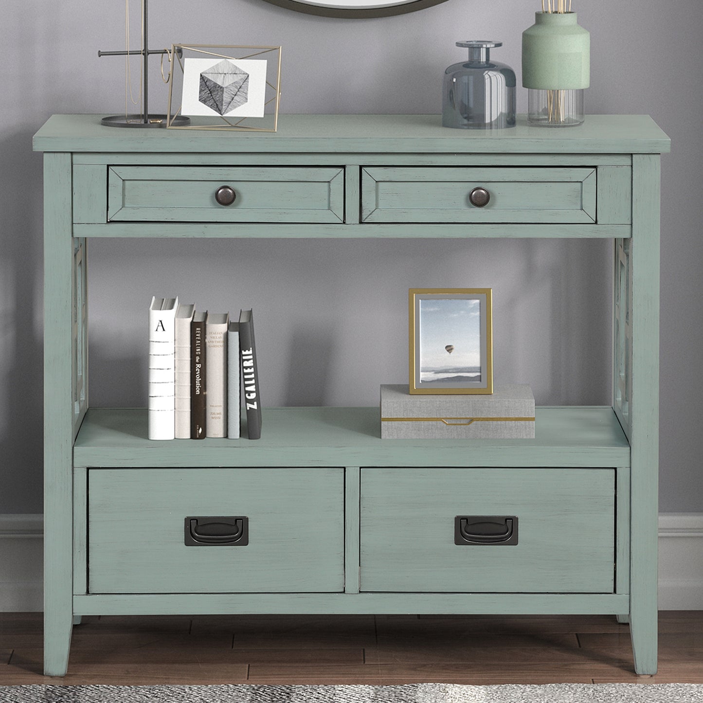 Distressed teal console table with four drawers and open shelf displaying books and decor