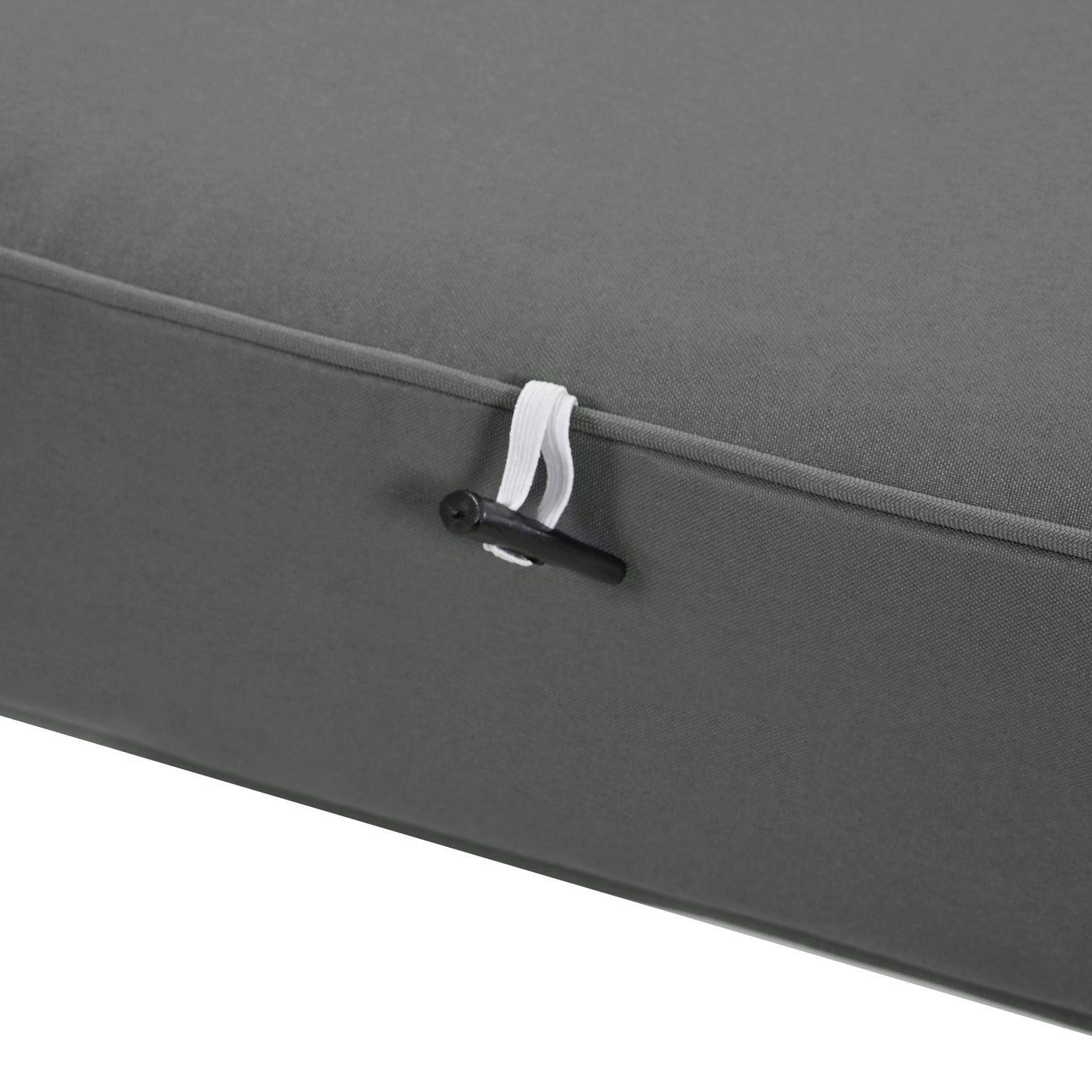 Closeup of a dark gray outdoor cushion with a white elastic tie and black toggle
