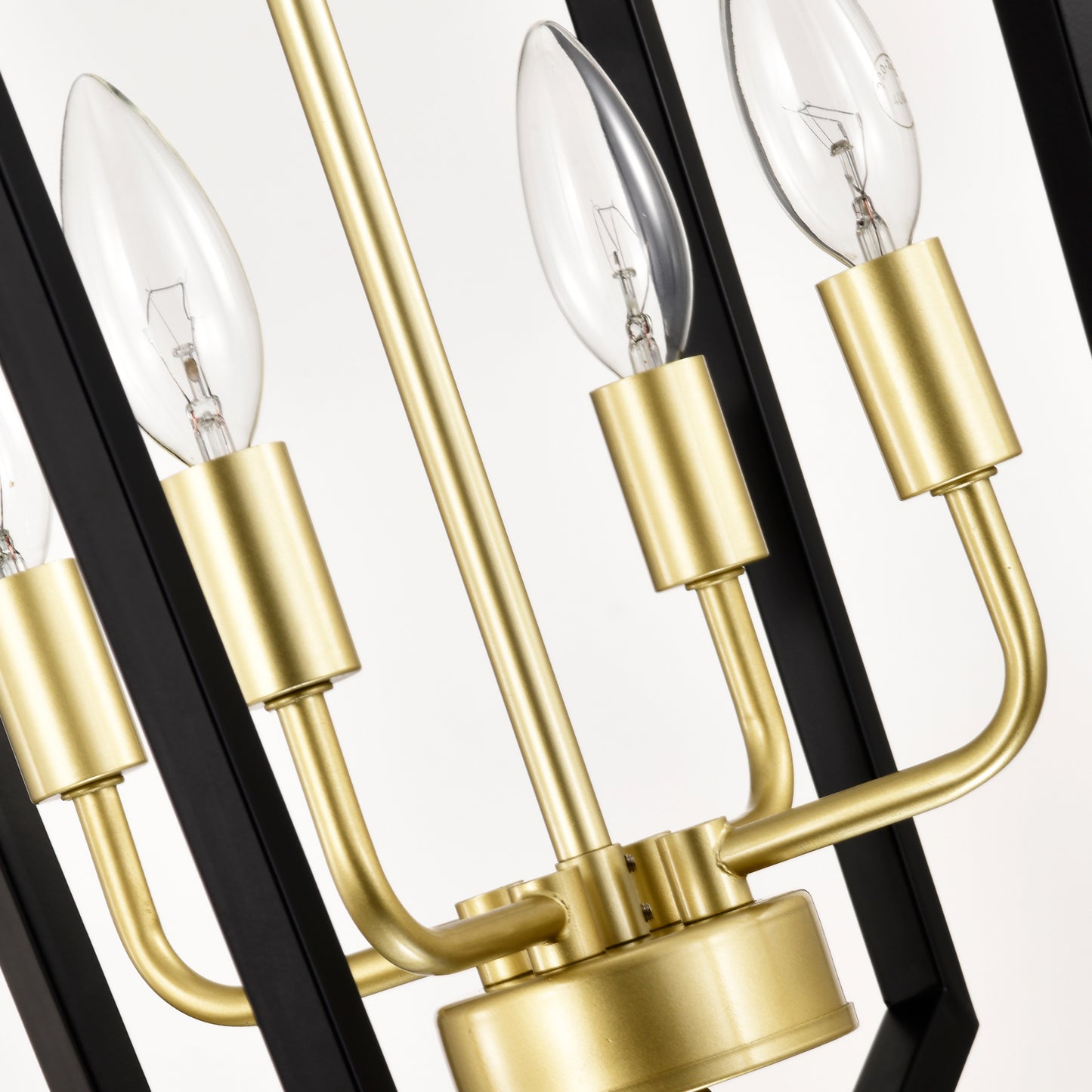 Closeup of a modern brass chandelier with clear Edison bulbs and black metal accents