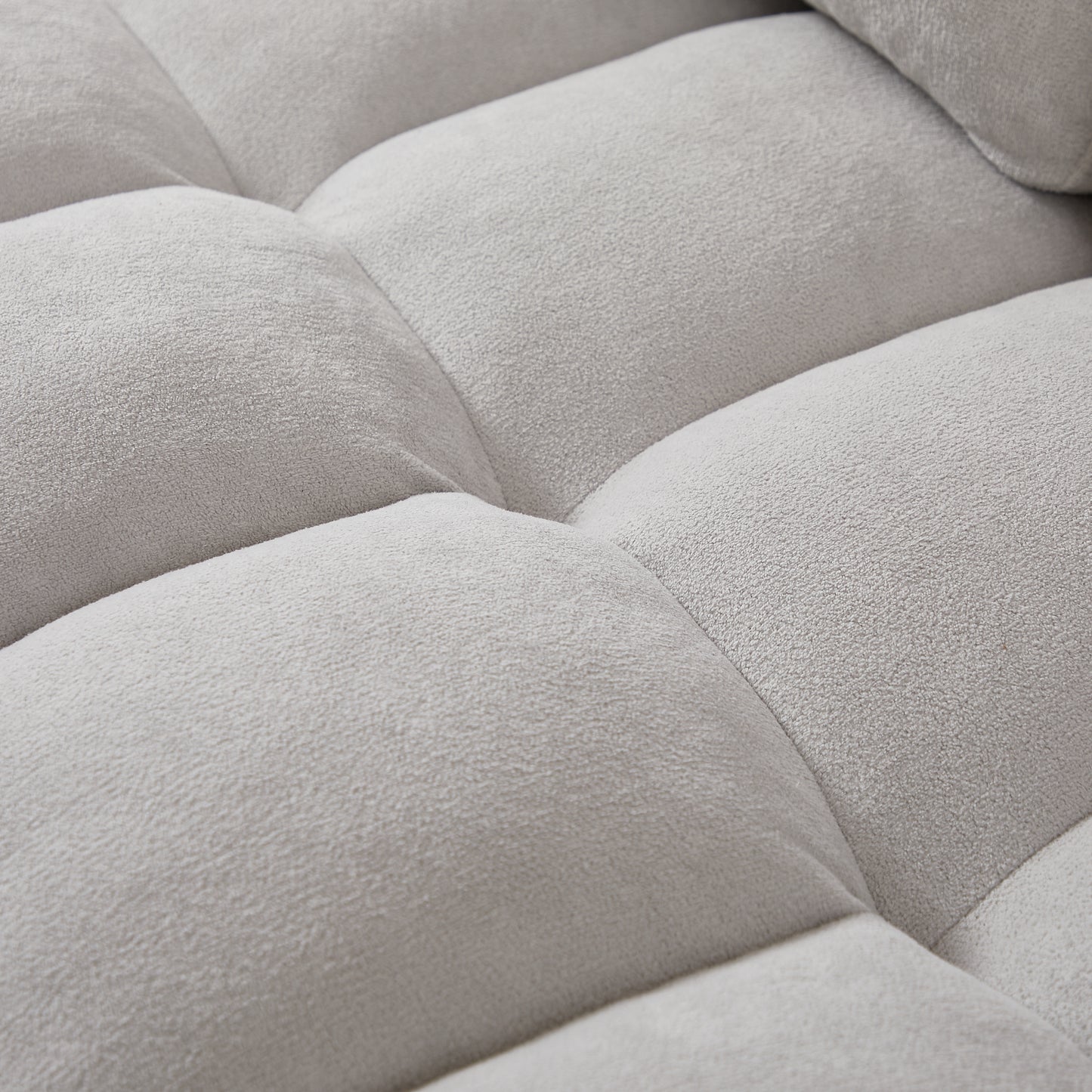 Closeup of tufted light grey velvet sofa cushion texture soft and inviting