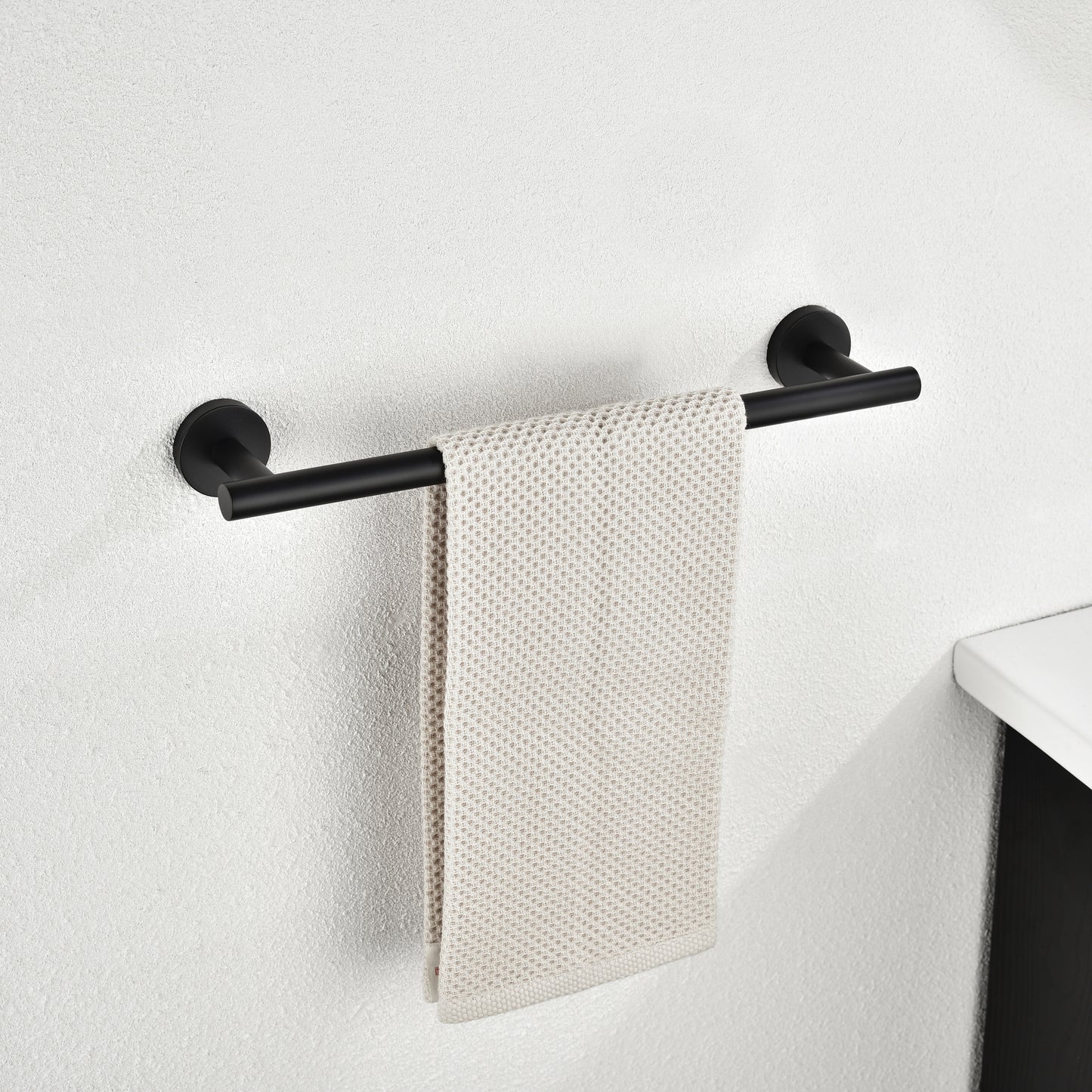 Black modern wallmounted towel bar with a single beige waffleweave towel