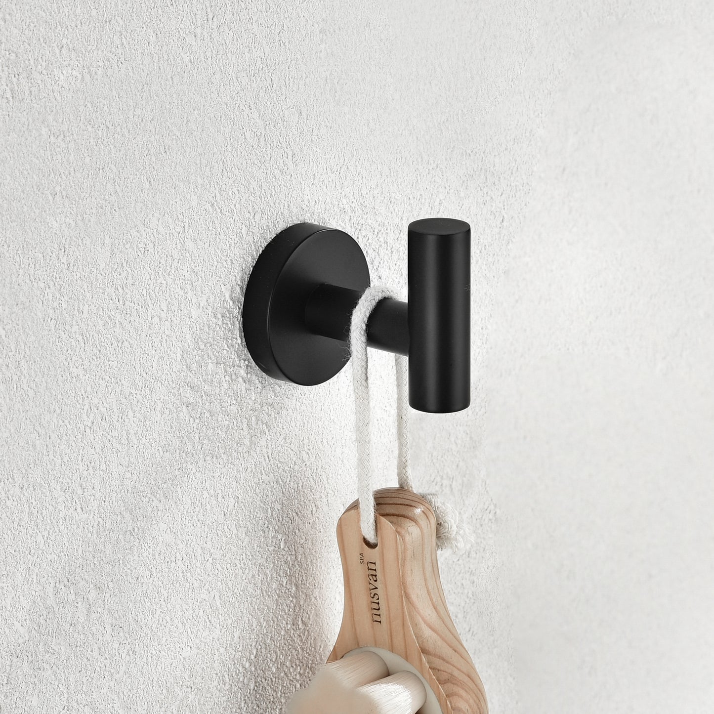 Modern matte black wall hook with cylindrical shape ideal for bathroom towels