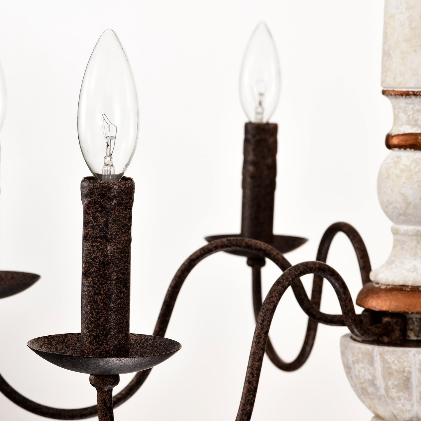 Closeup of an antiquestyle chandelier with ornate arms and candleshaped bulbs