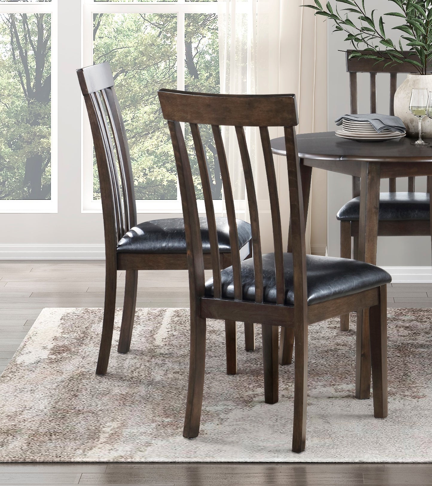 Dark wood dining chairs with black leather seats and slatted backs