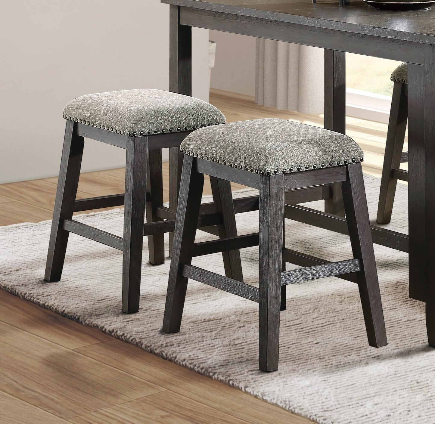 Dark wood counter stools with grey upholstered seats and nailhead trim