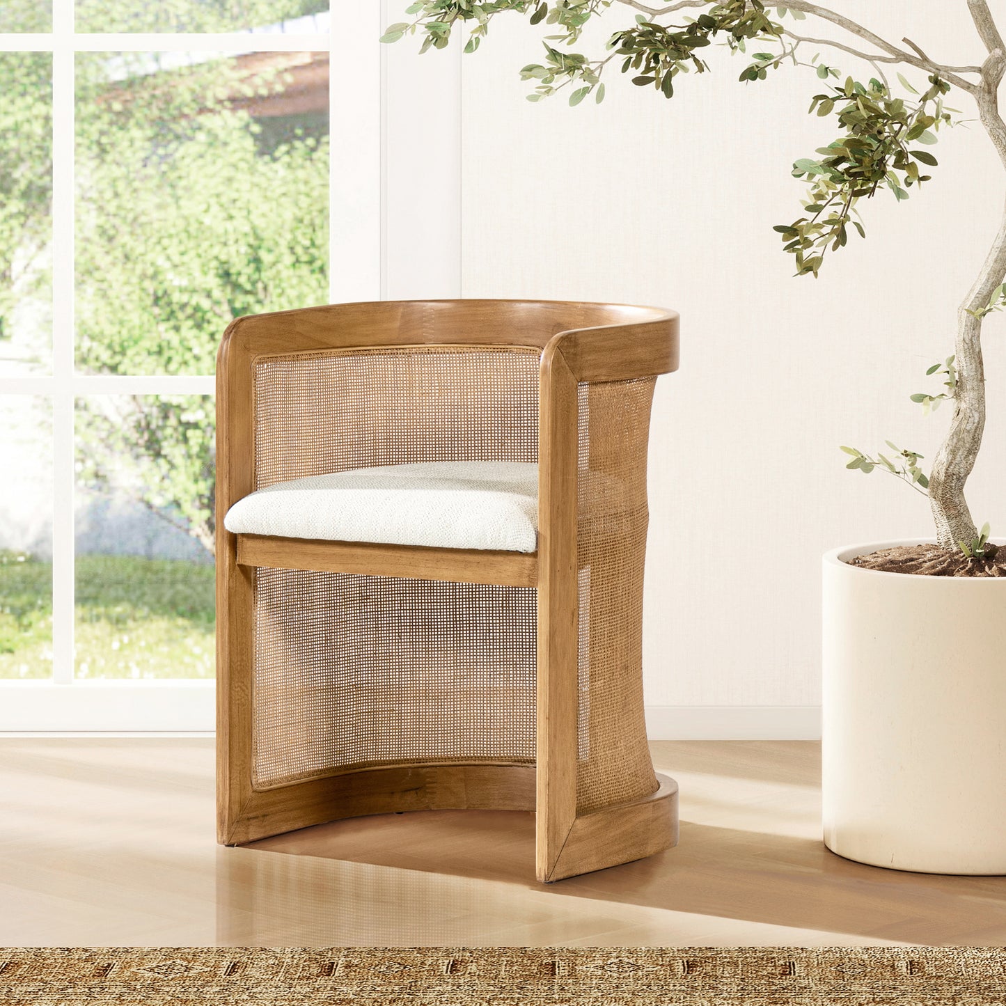 Natural wood armchair with woven cane back and a plush white seat cushion blending midcentury and coastal styles