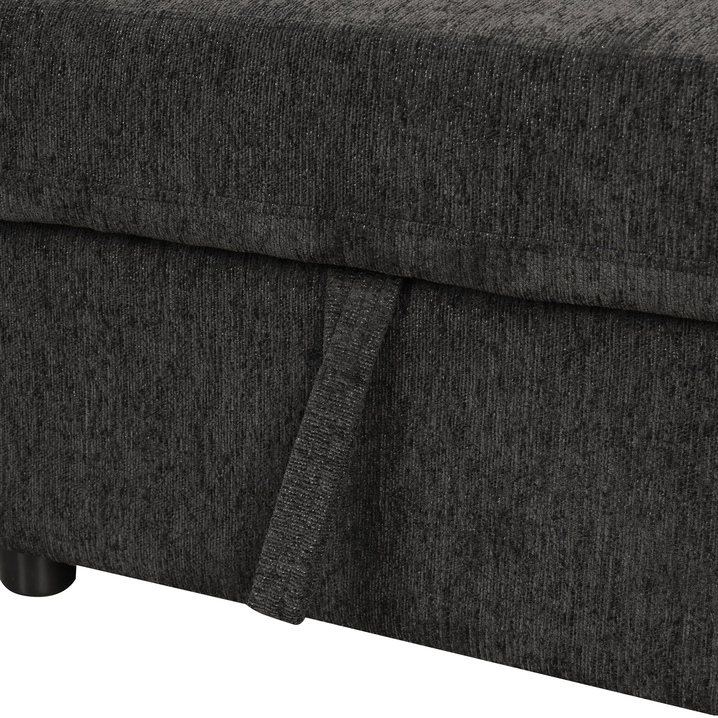 Closeup of dark gray textured fabric on a couch with a pull tab