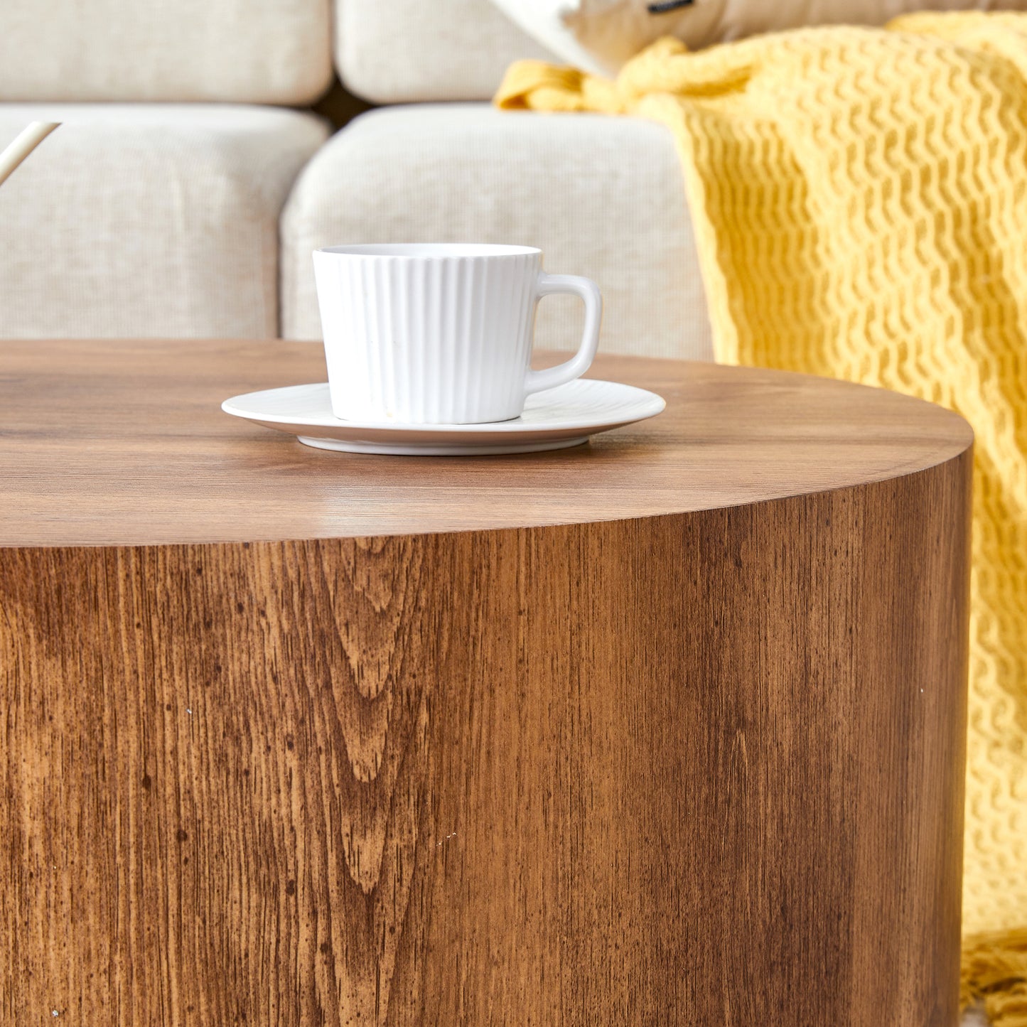 Modern cylindrical wood coffee table with a warm natural grain finish