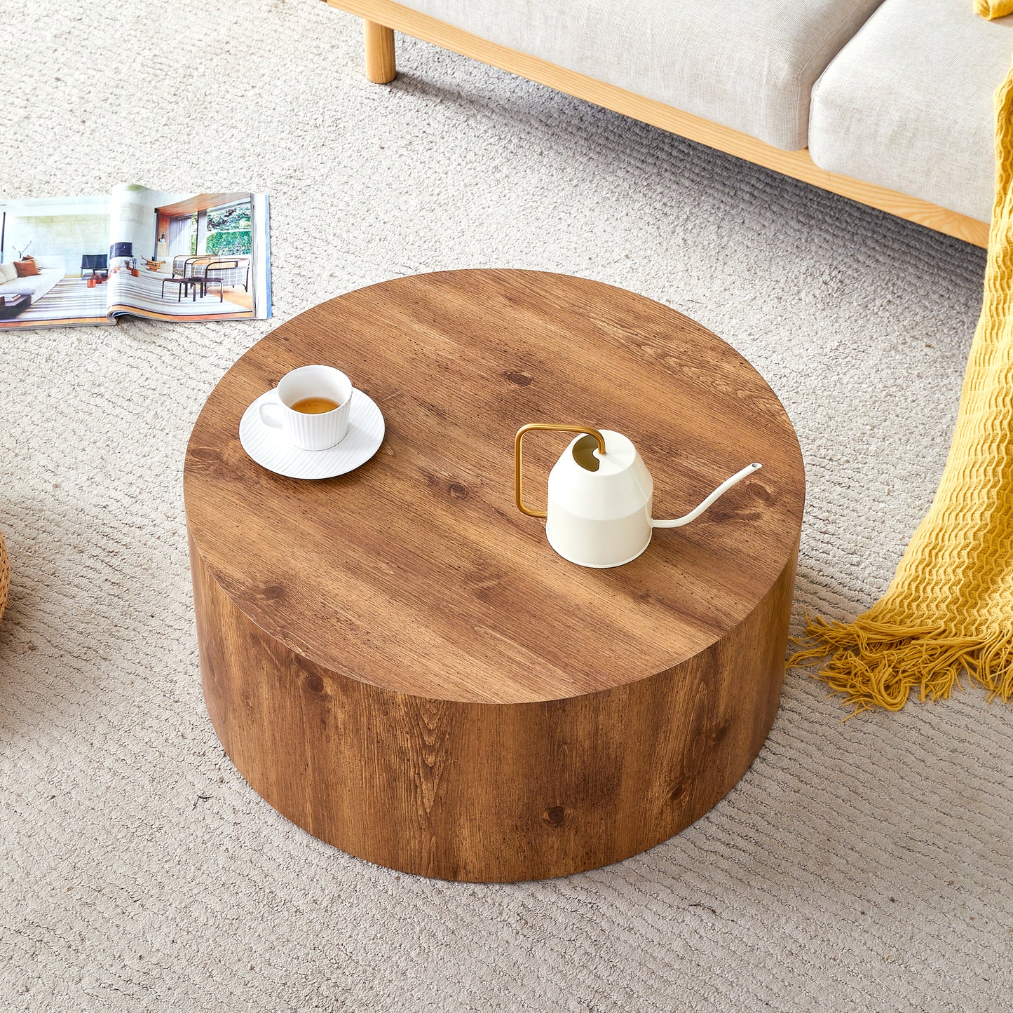 Round wooden coffee table with a white tea cup and a small watering can
