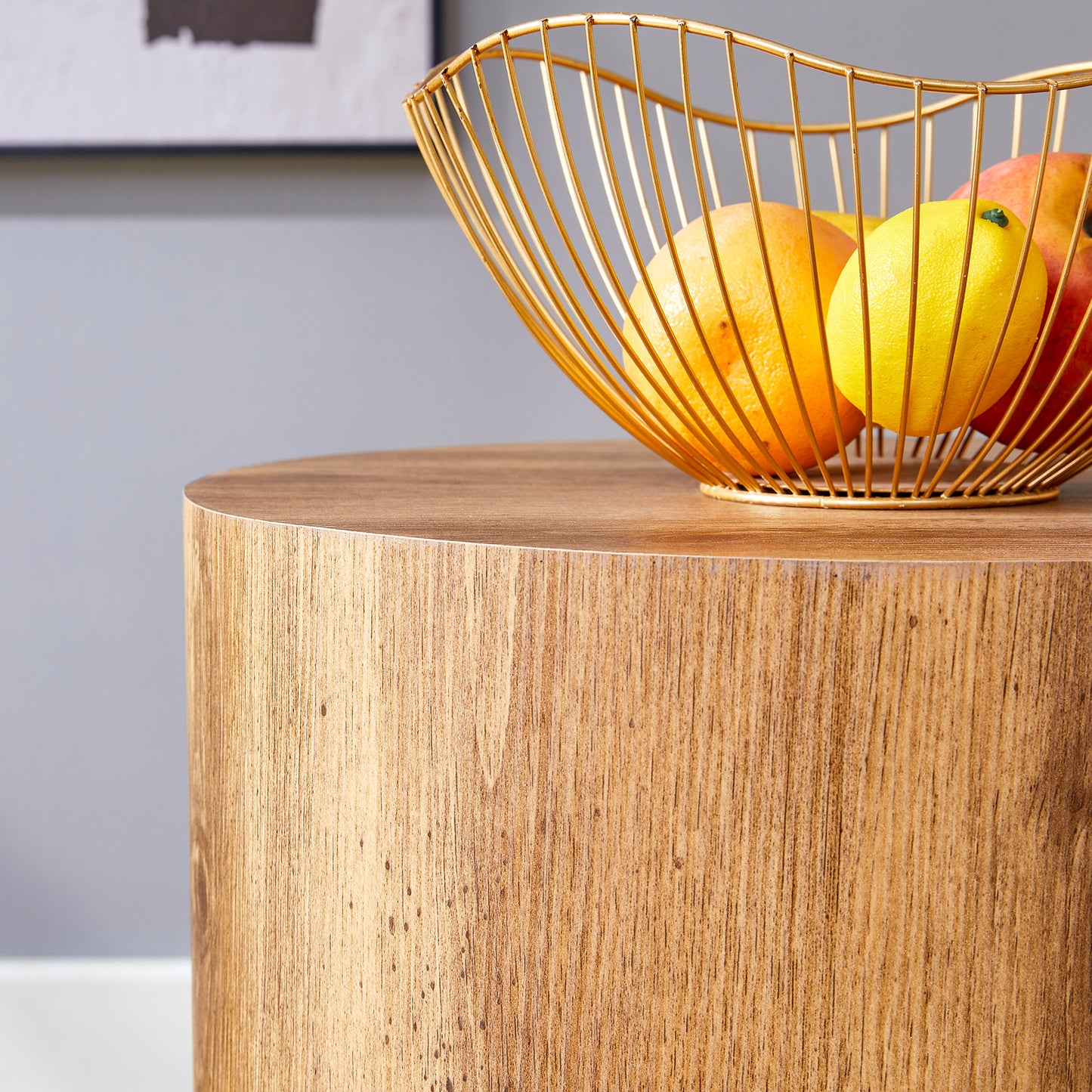 Gold wire fruit bowl with oranges lemons and apples on wooden table