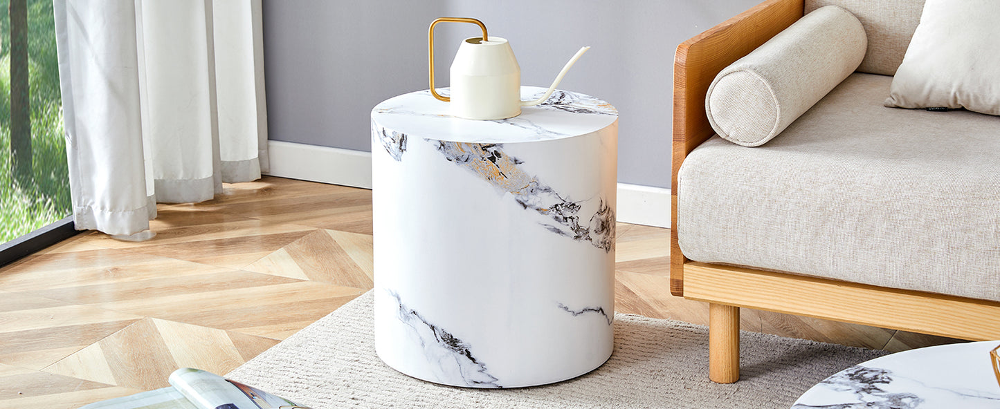 Cylindrical white marble side table with gold accents and a decorative watering can