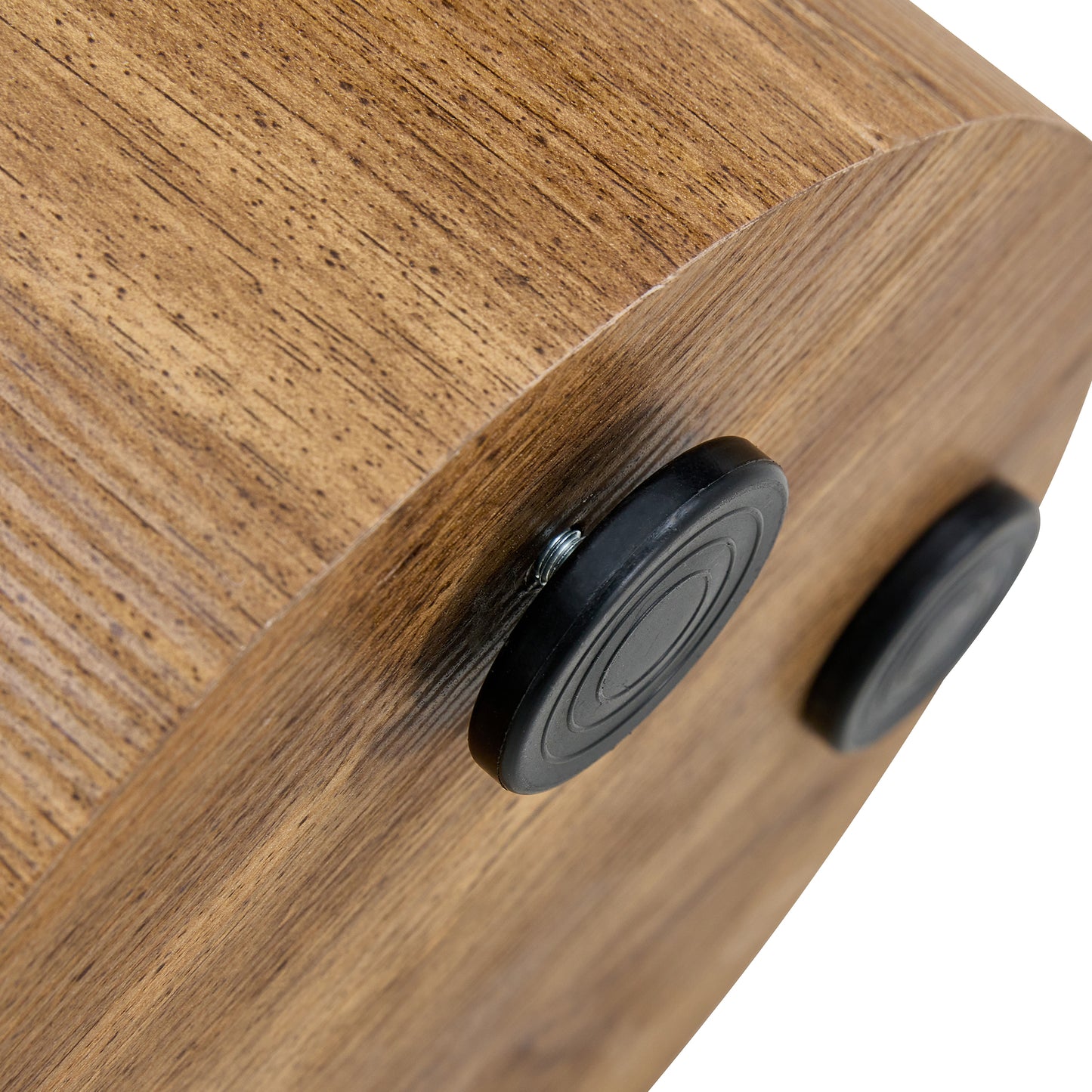 Closeup of a rustic woodgrain shelf with black rubber feet attached