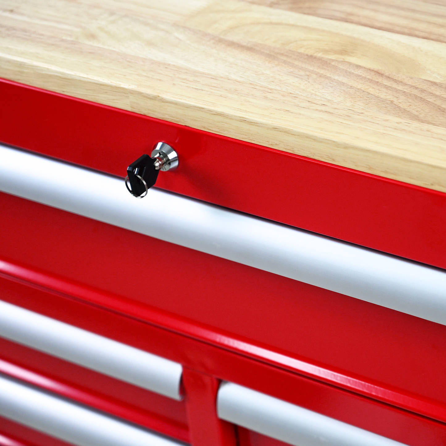 Red metal rolling tool chest with wooden top and key lock detail