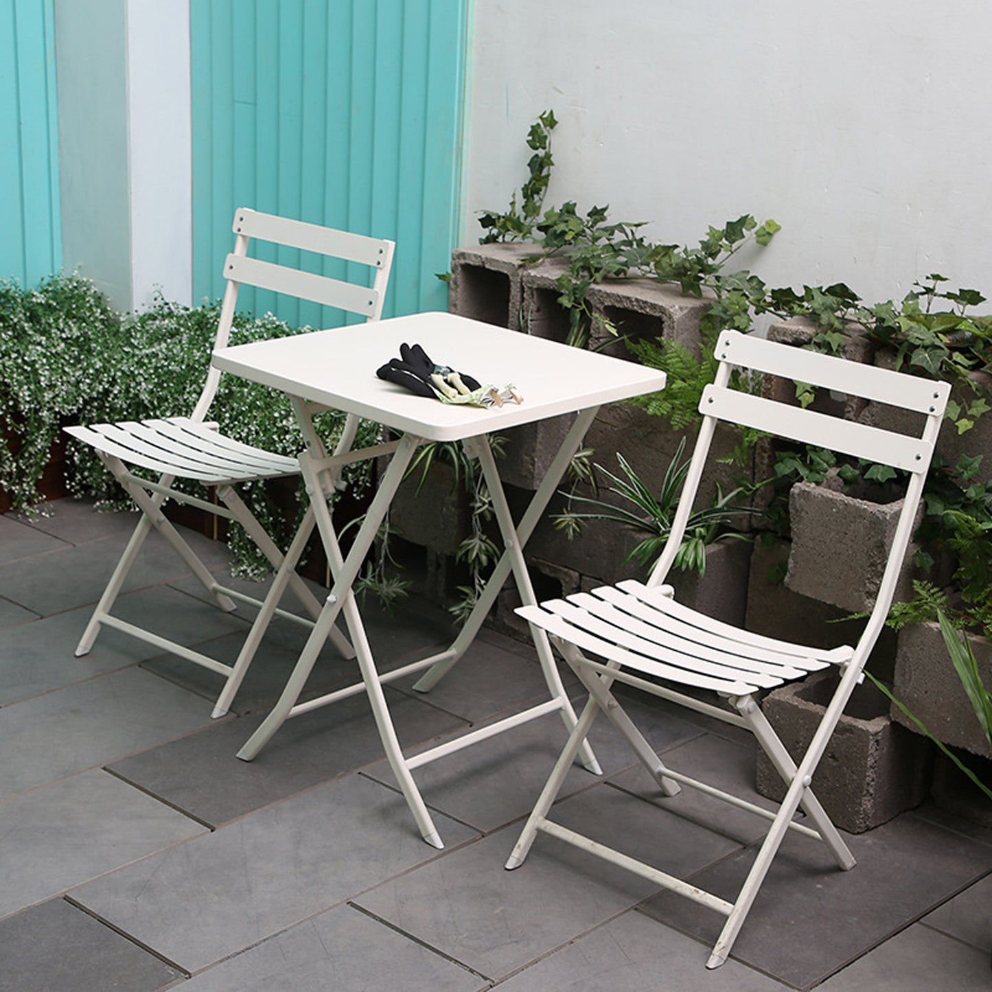 White metal folding bistro set with two chairs and a square table