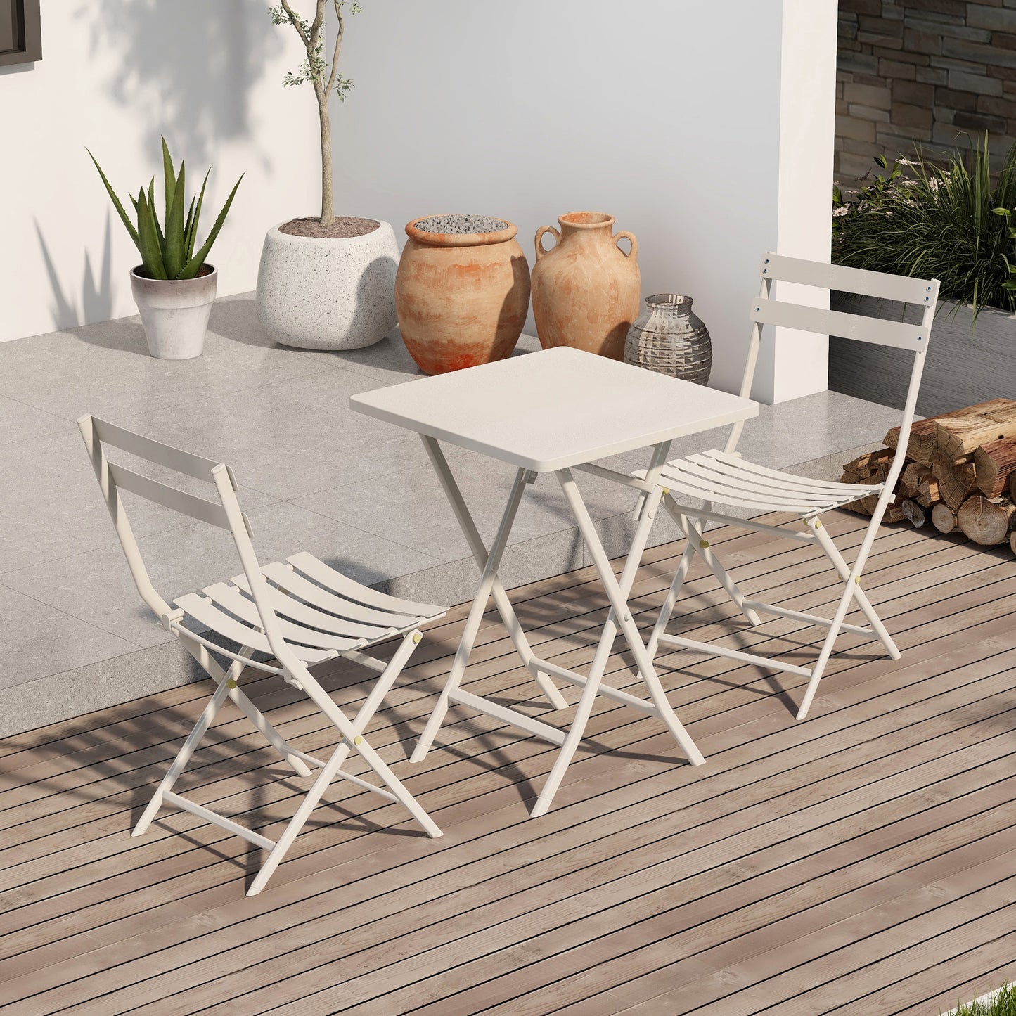 White metal bistro set with a square table and two chairs on a wooden deck