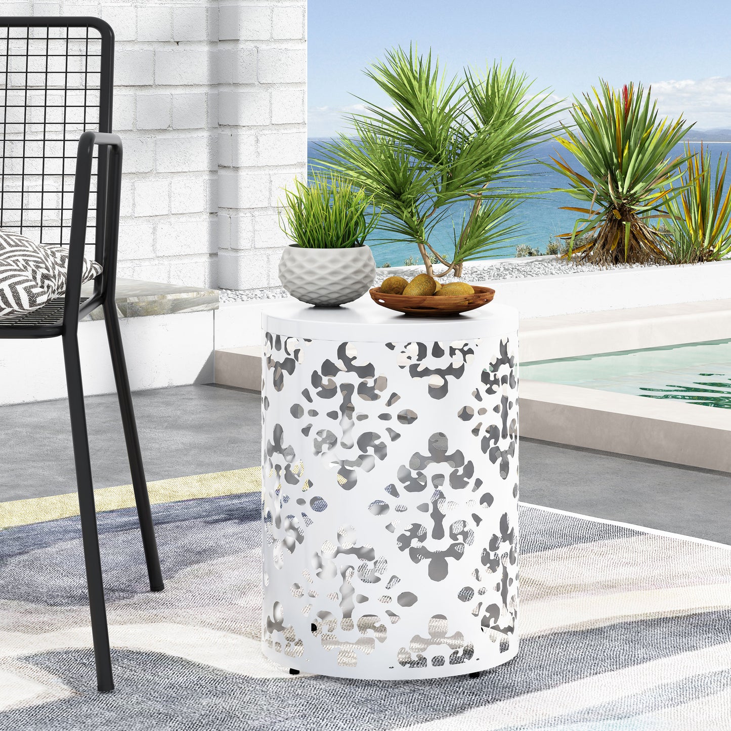 White metal patio side table with lasercut floral pattern for outdoor use