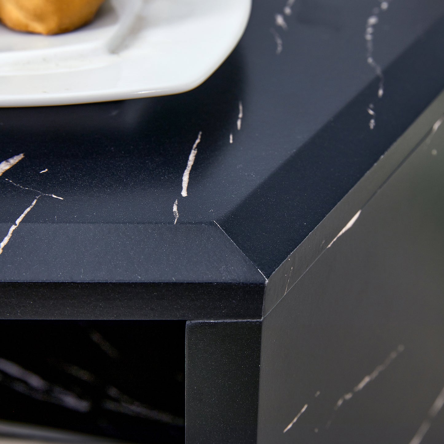 Black marble effect countertop with white veining and a beveled edge