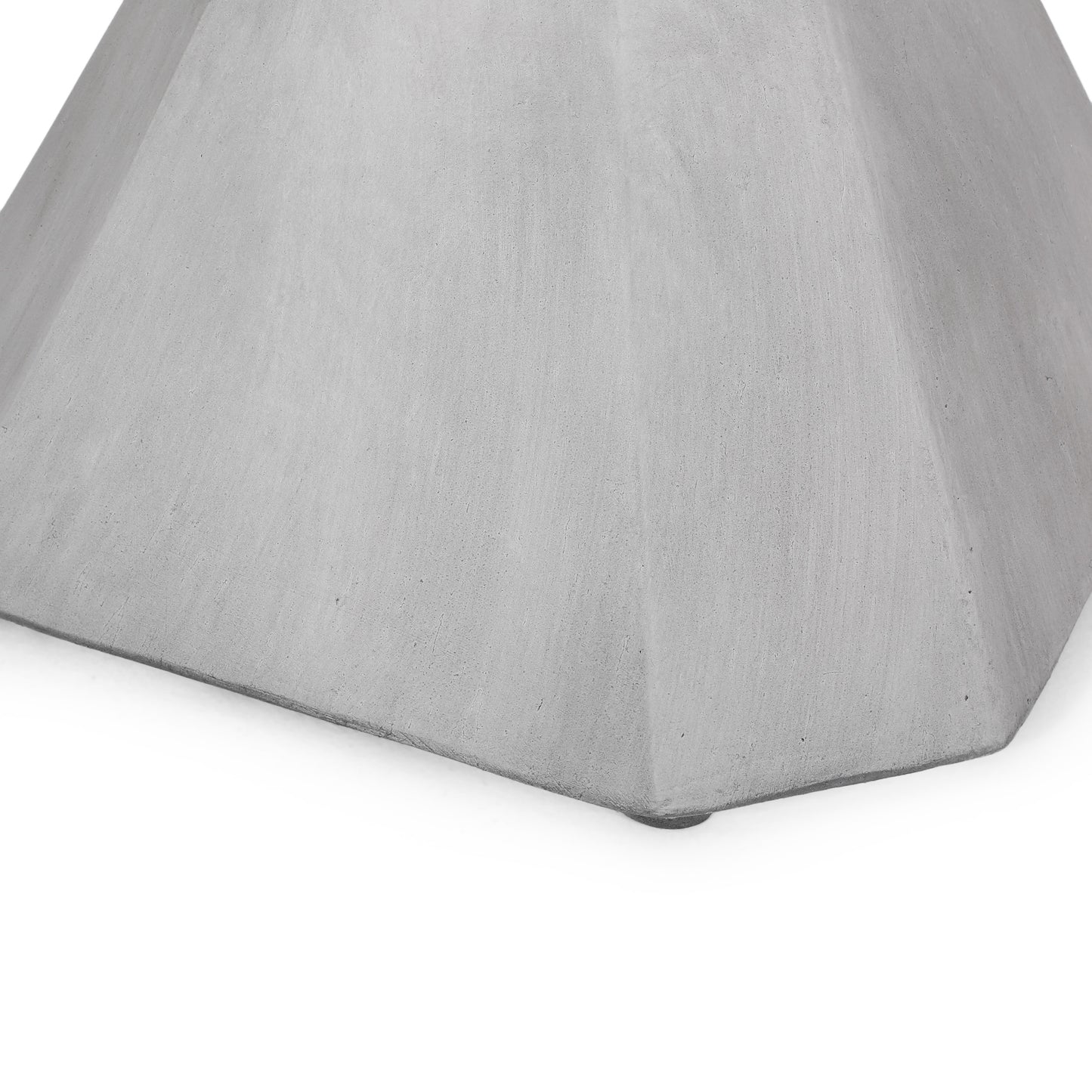 Closeup of a grey concrete planter base with faceted sides
