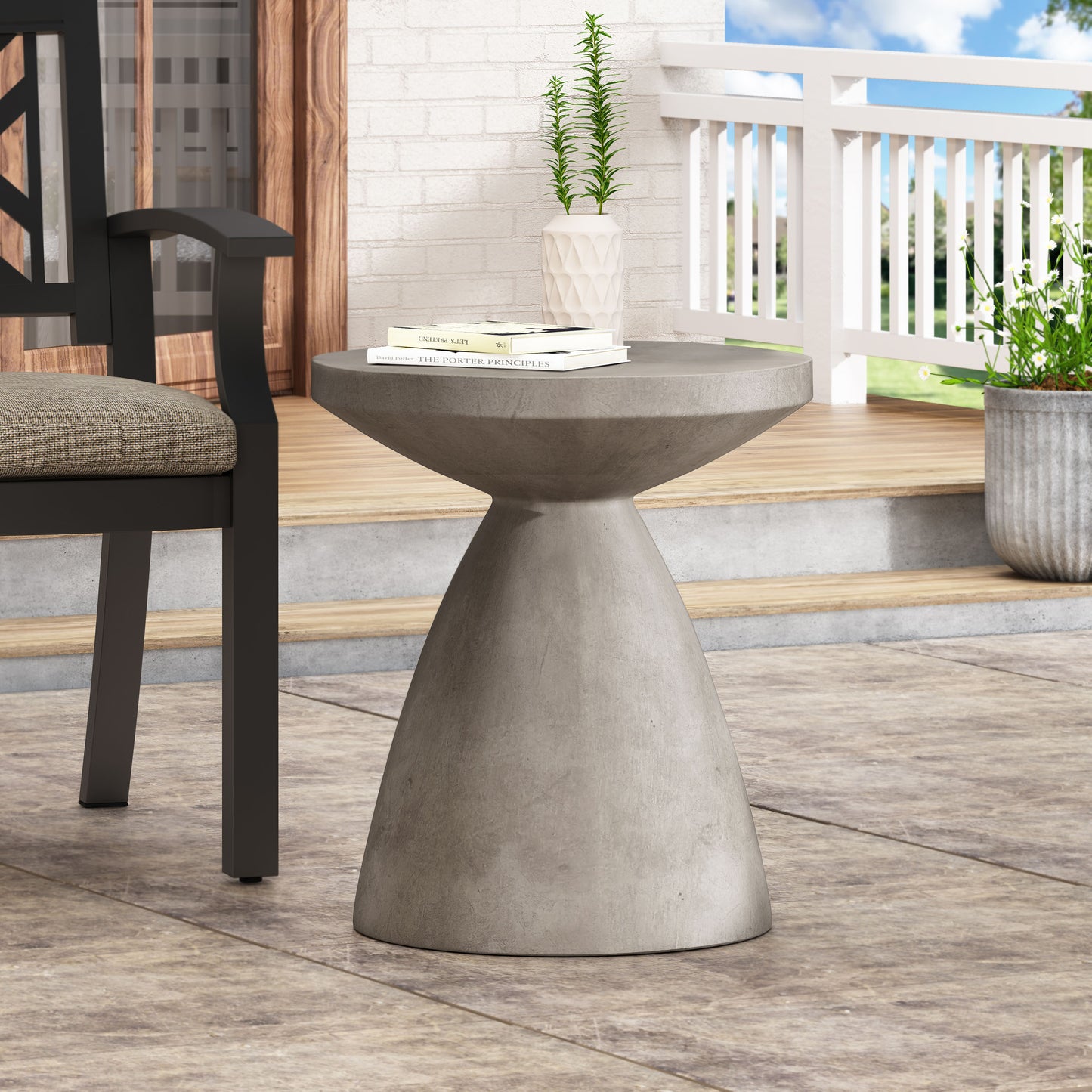 Grey concrete hourglass side table with a flat top on a patio