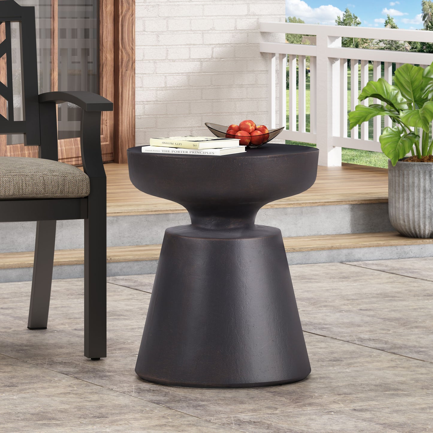 Dark bronze outdoor accent table with a unique flared pedestal base perfect for patios