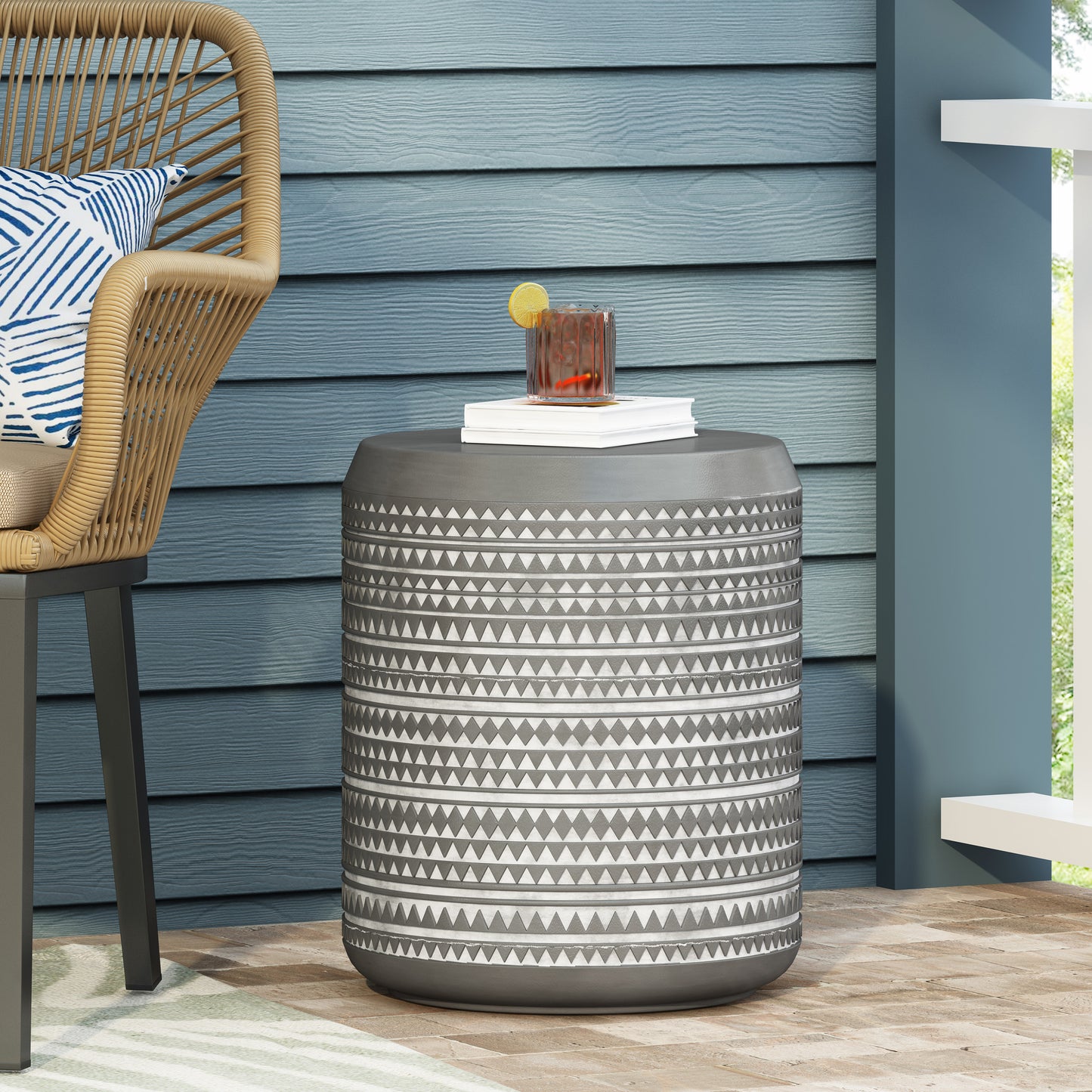 Gray round outdoor accent table with geometric pattern and textured rim