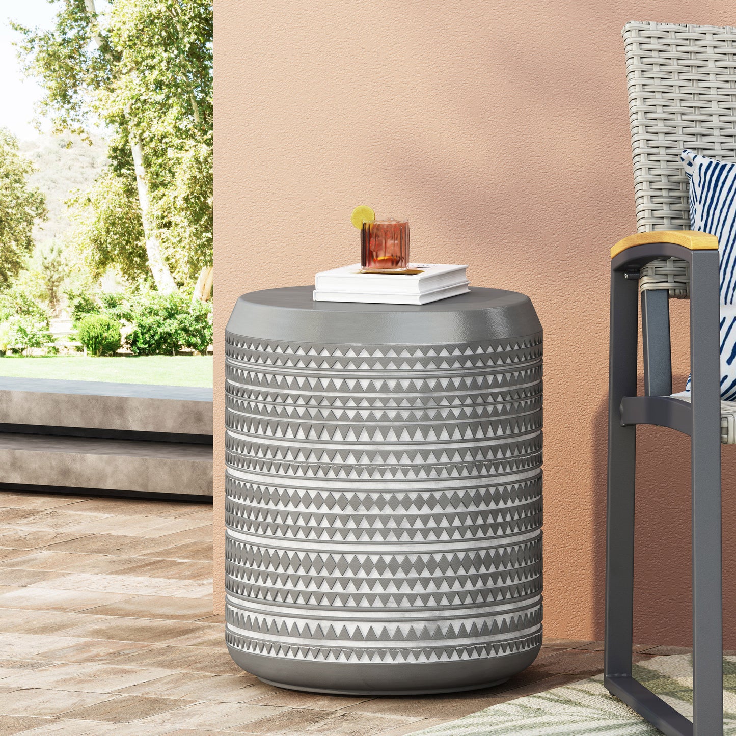 Grey geometric pattern patio side table with drink and books