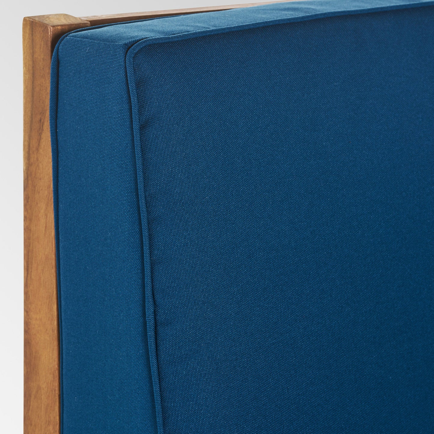 Teak wood frame with plush navy blue outdoor cushion detail