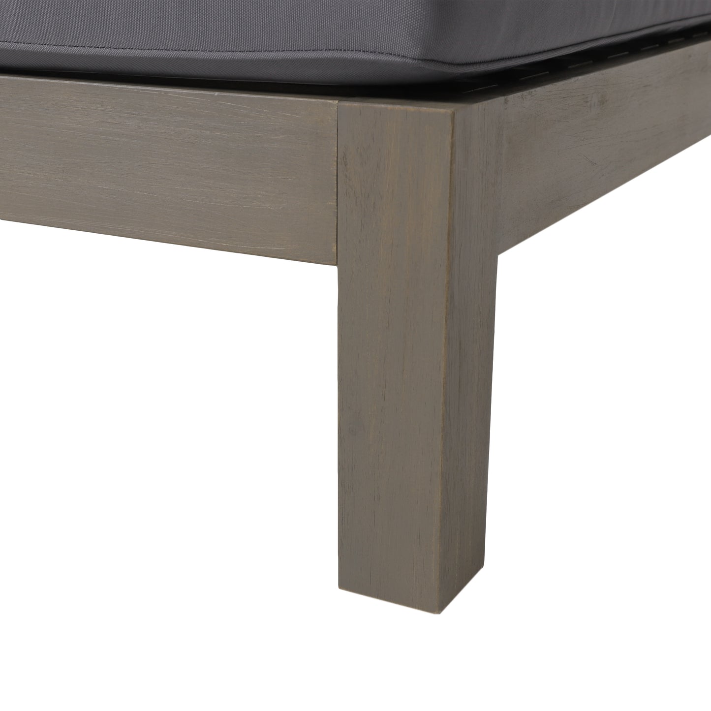 Closeup of grey wooden frame corner with dark grey cushion of an outdoor chaise lounge