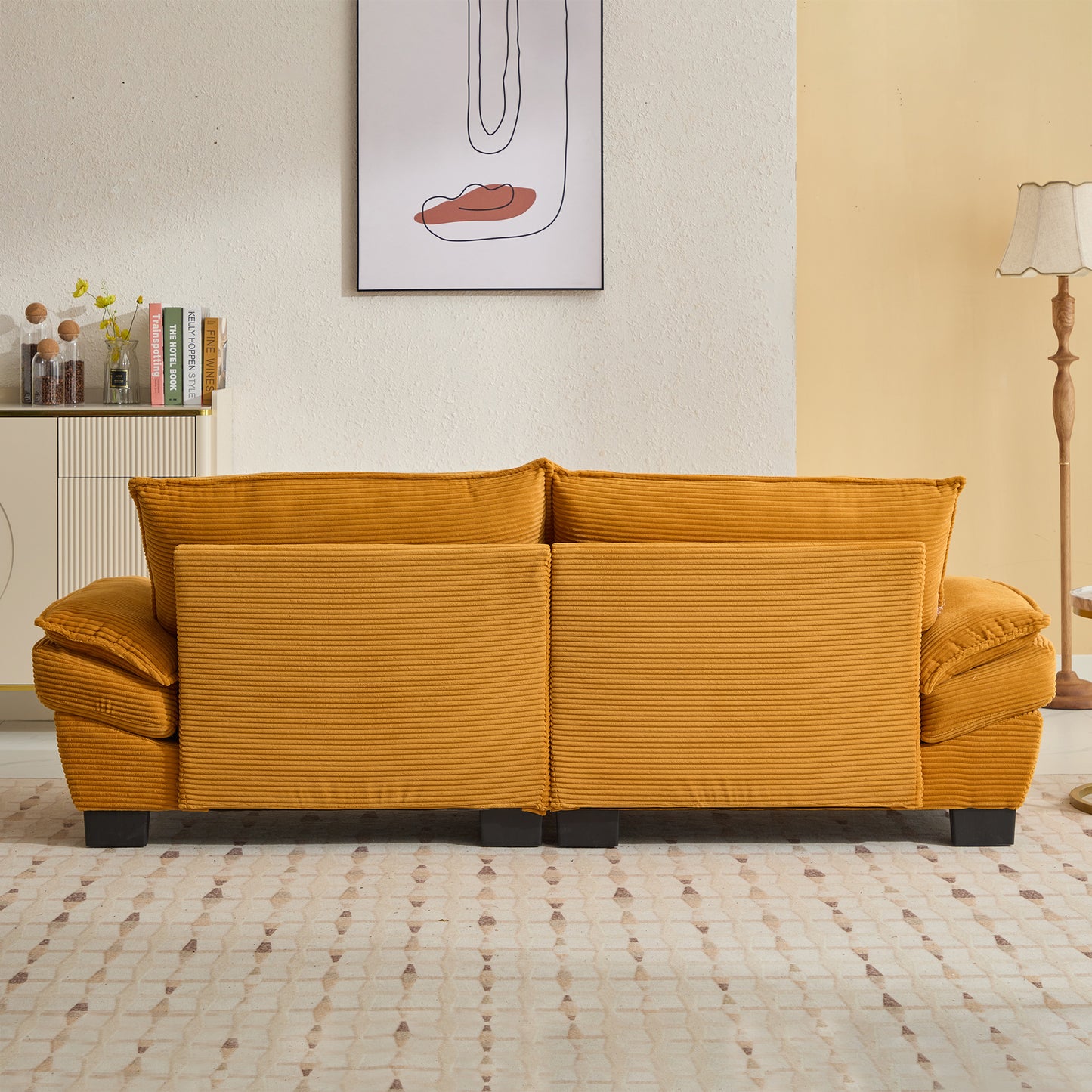 Mustard yellow corduroy sofa with plush cushions and black legs