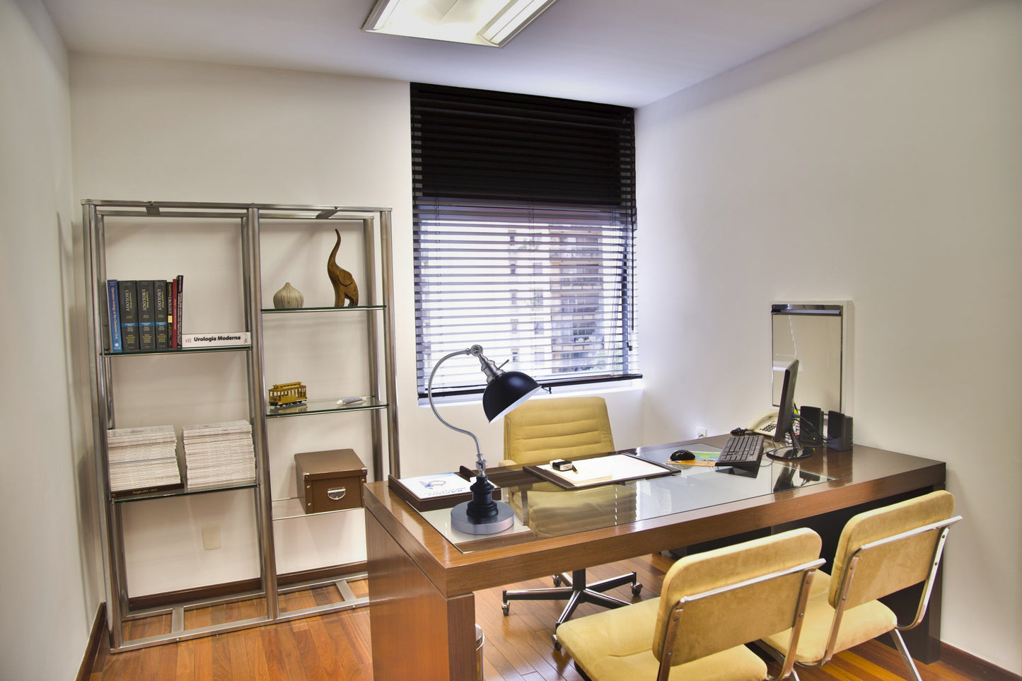 Modern executive desk with glass top and two yellow chairs for office use
