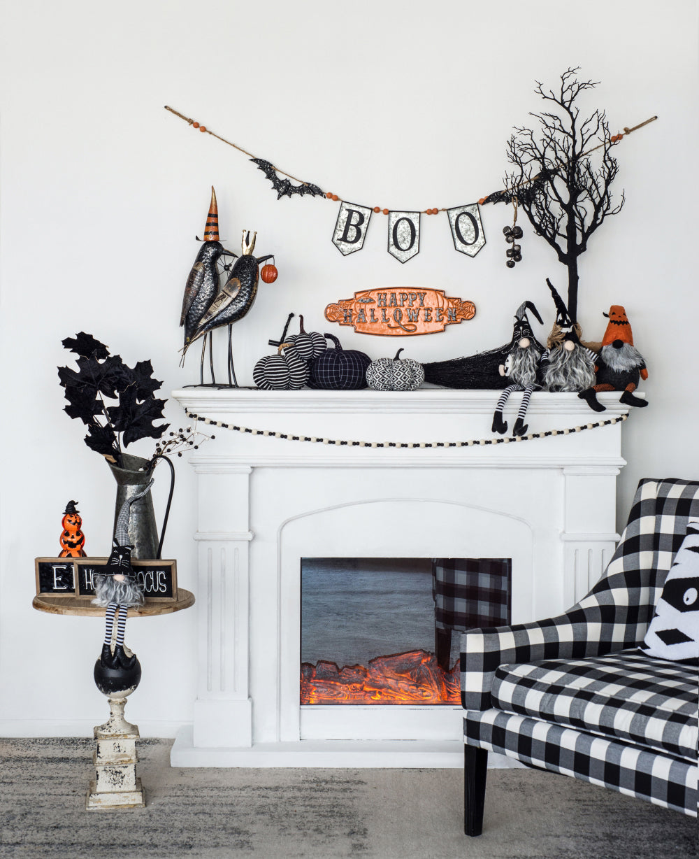 Two black metal bird figurines with orange hats adorn a mantelpiece perfect Halloween decor