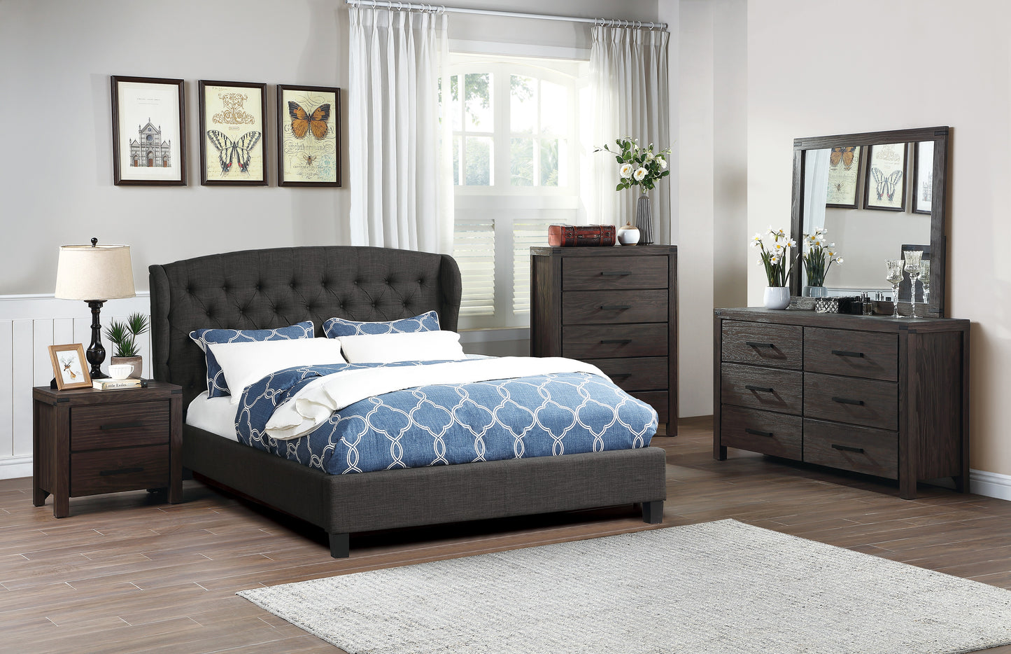 Dark grey upholstered bed with tufted headboard and blue patterned duvet