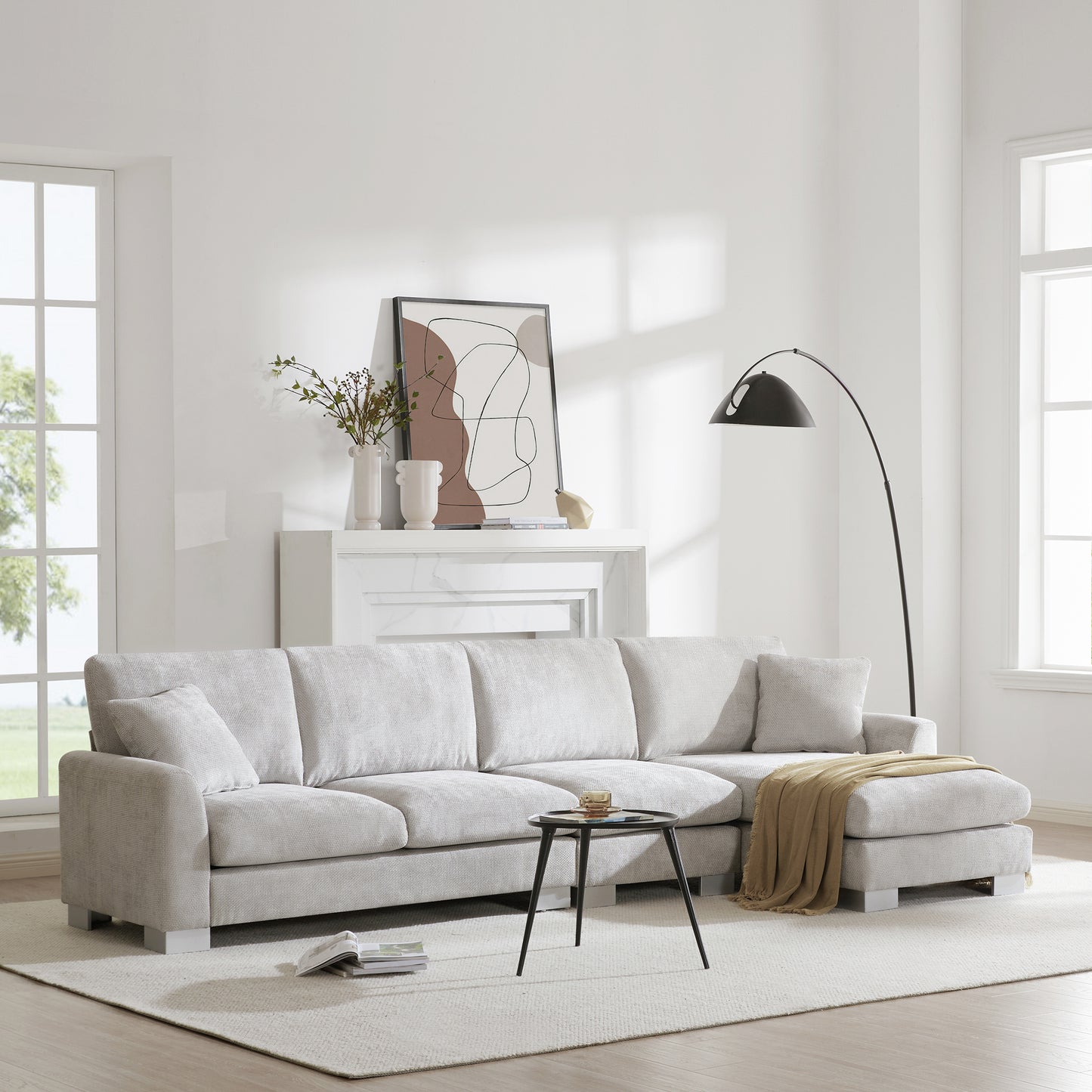 Light gray sectional sofa with chaise lounge and throw blanket perfect for living rooms