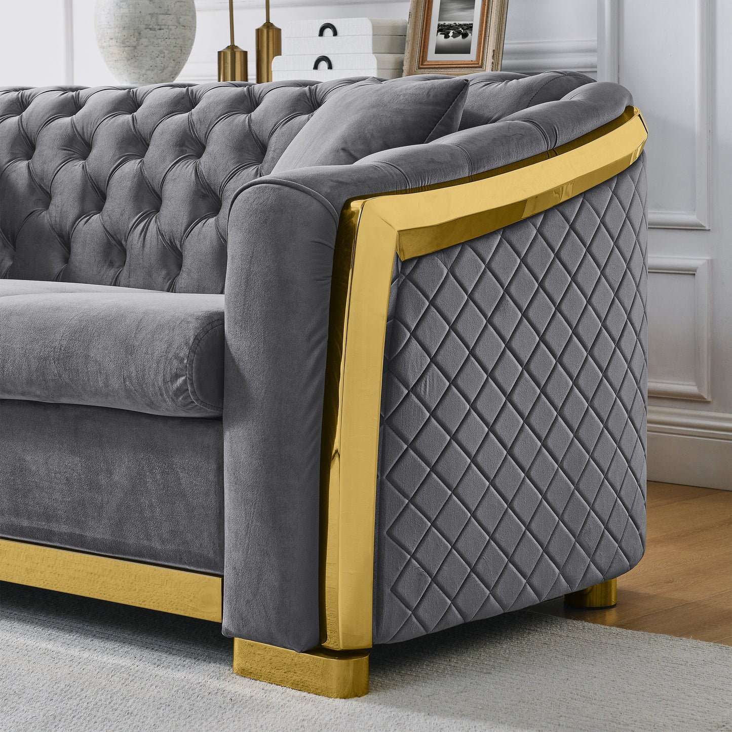 Tufted grey velvet sofa with diamondstitched side and gold trim accent