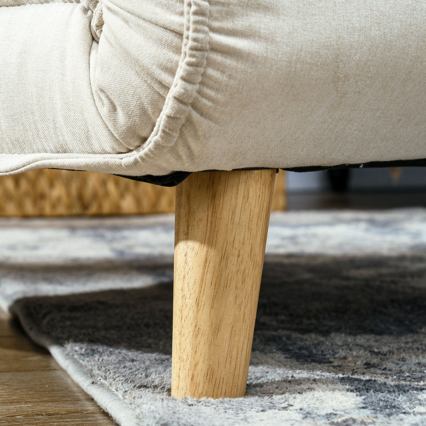 Closeup of beige linen sofa upholstery detail with wooden leg