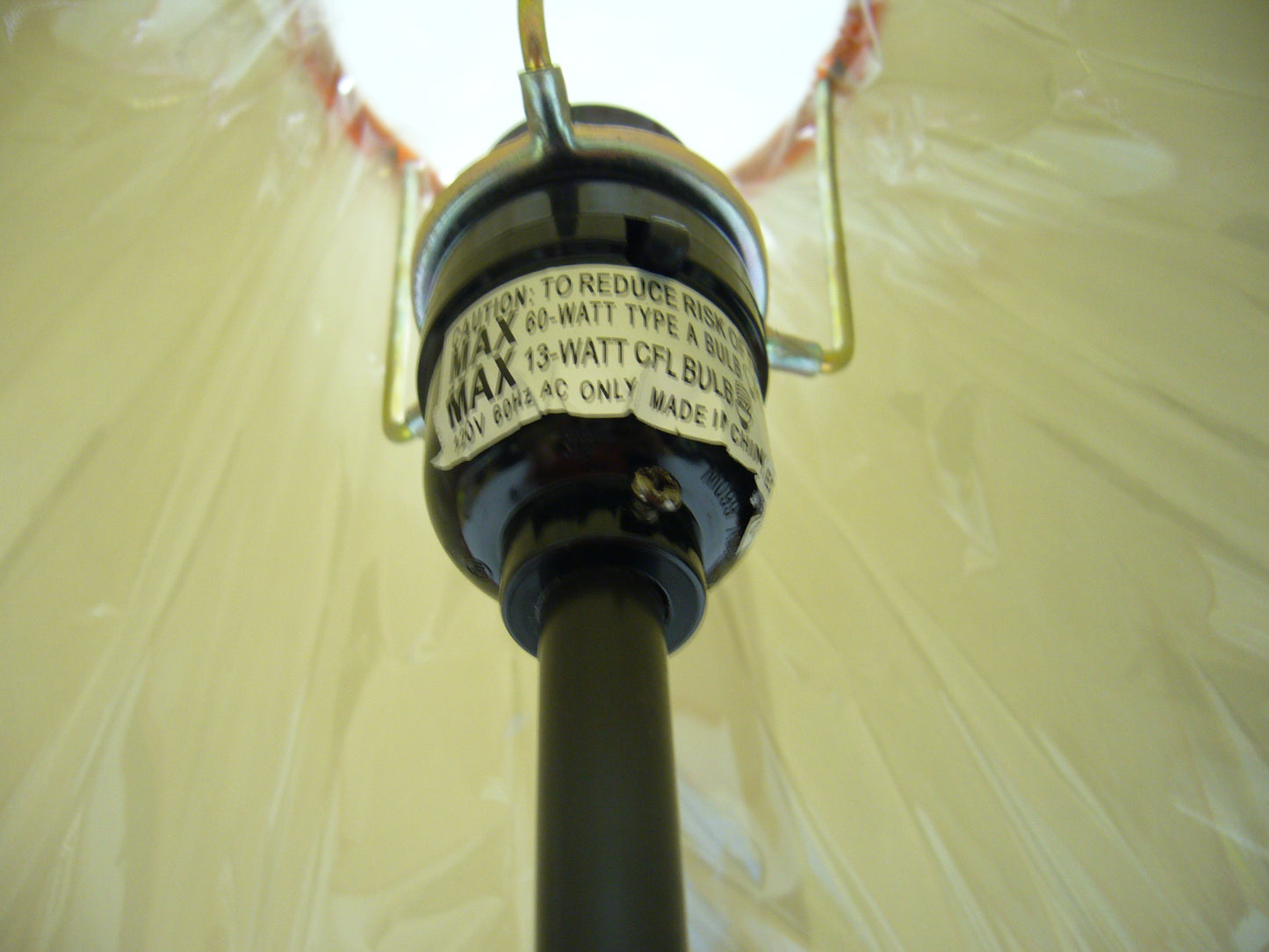 Closeup of a lamp socket with a warning label indicating max watt type A bulb
