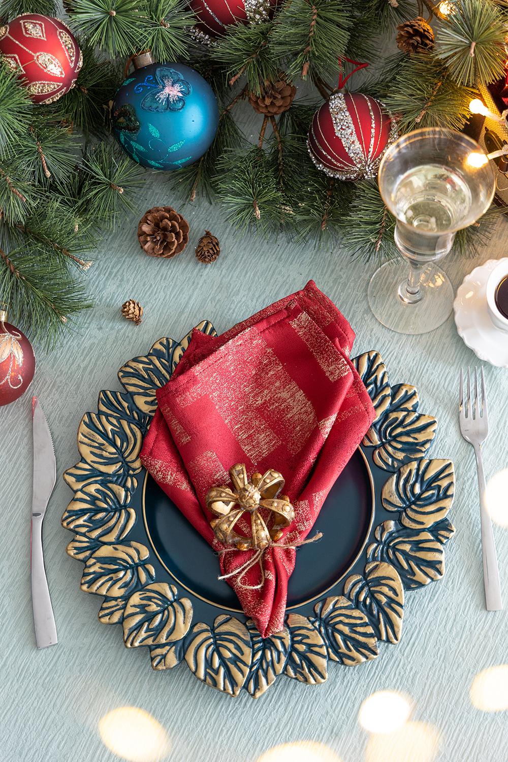 Red linen napkin with gold pattern and bow set for holiday dining