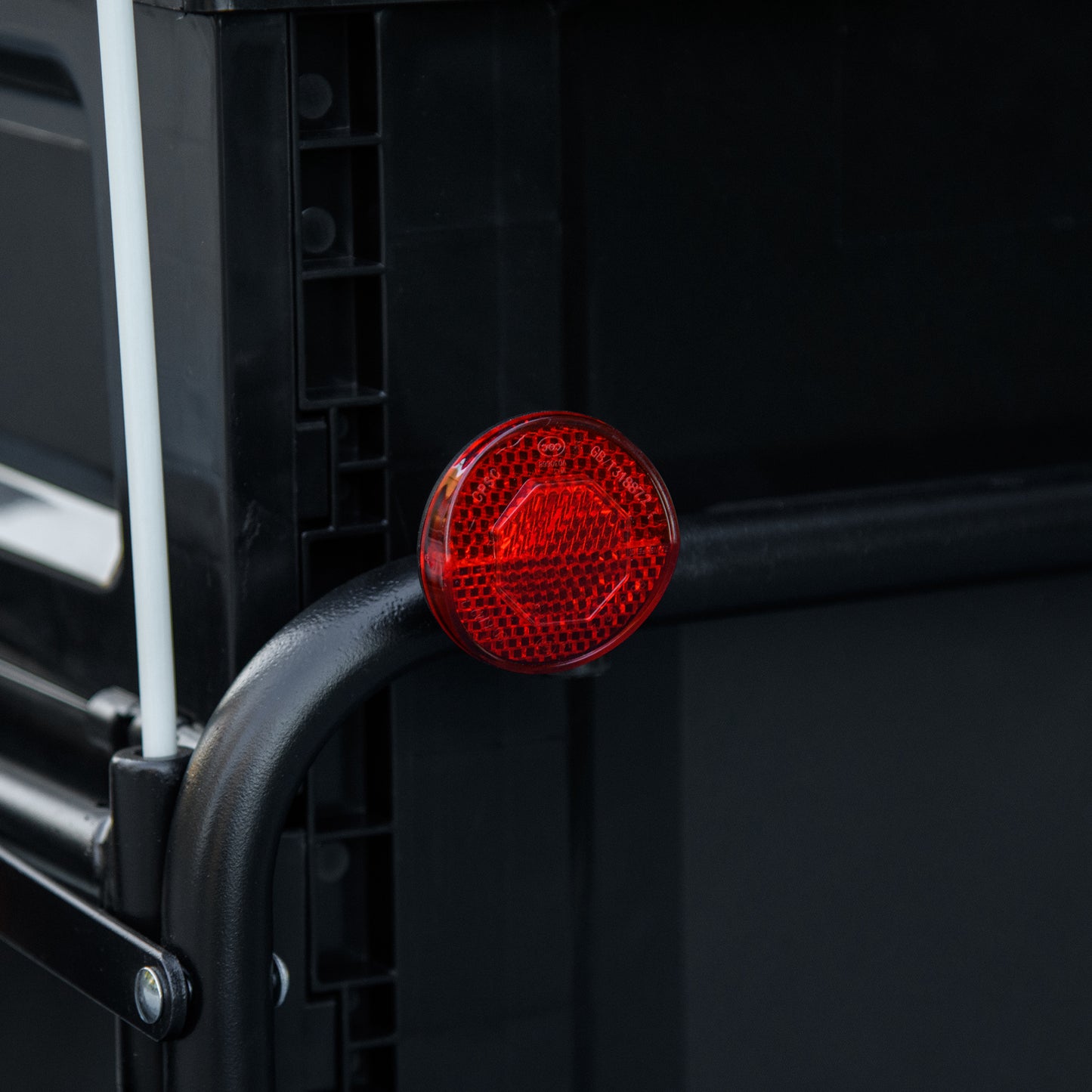 Round red bicycle reflector with hexagonal pattern and certifications
