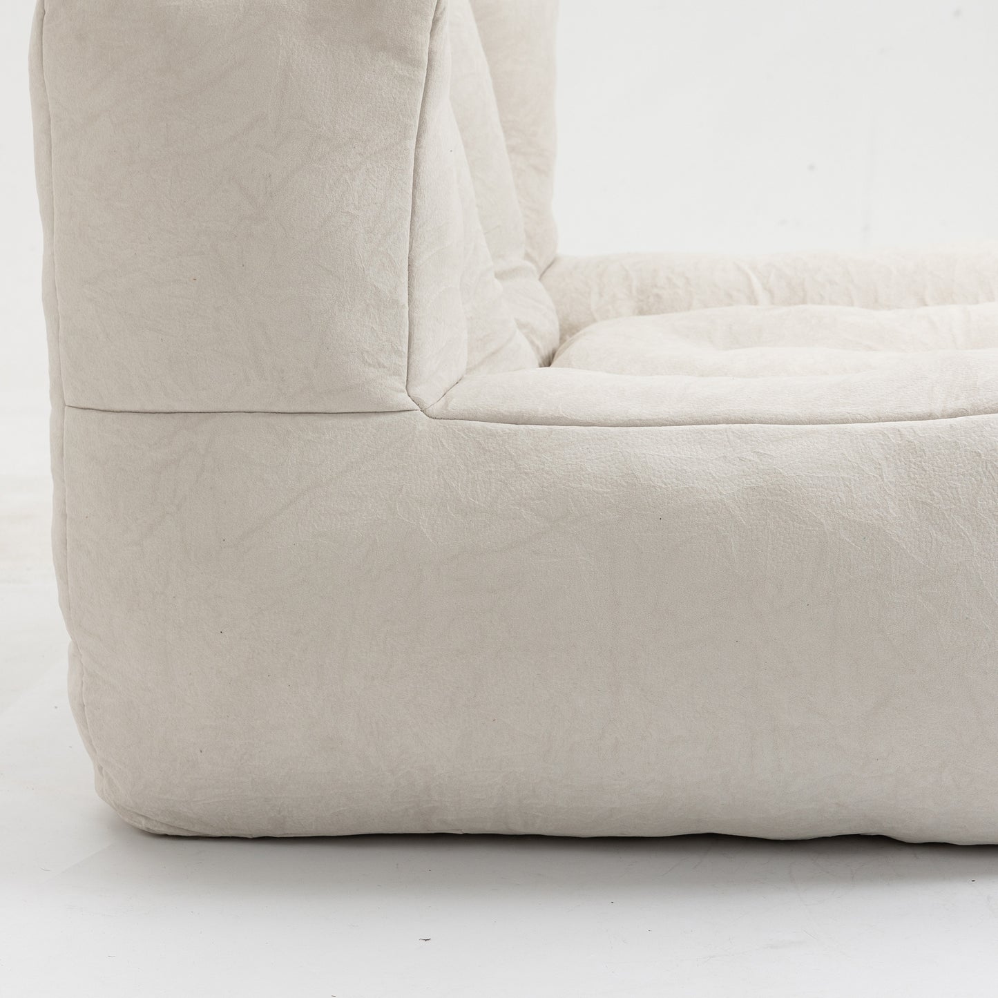 Closeup of a plush creamcolored boucle fabric armchair with soft rounded edges