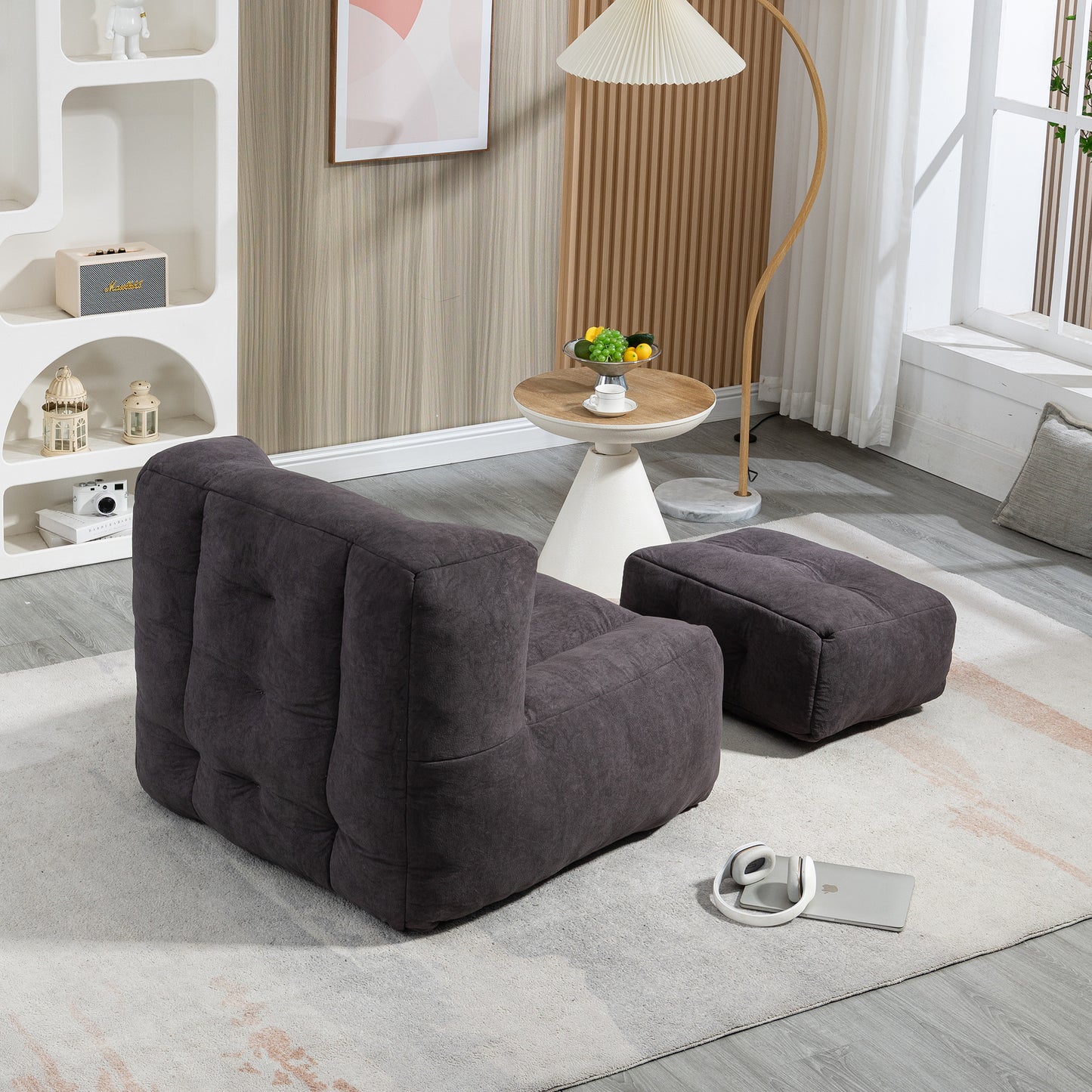 Dark gray tufted modular sofa and ottoman set in a modern living room