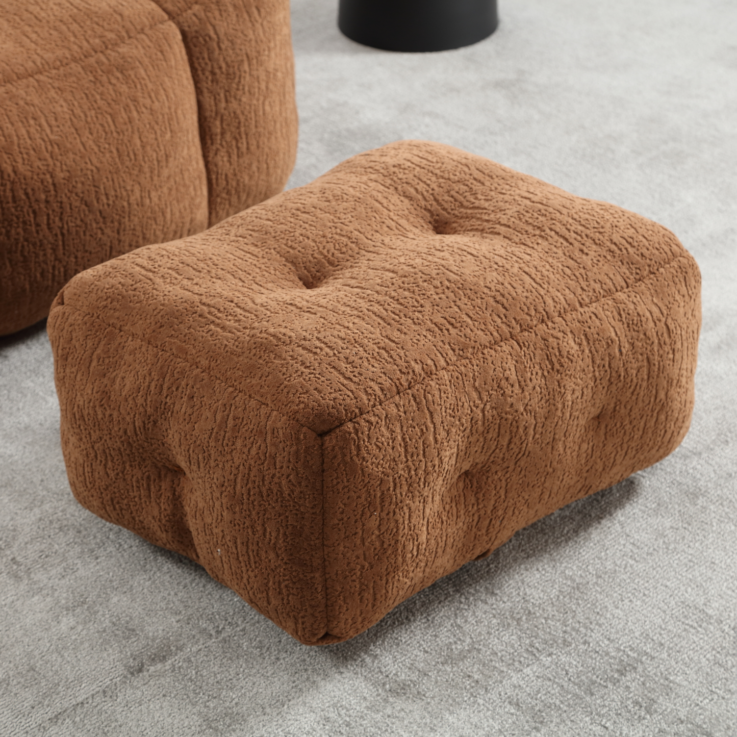 Tufted brown boucle ottoman with button accents on grey carpet