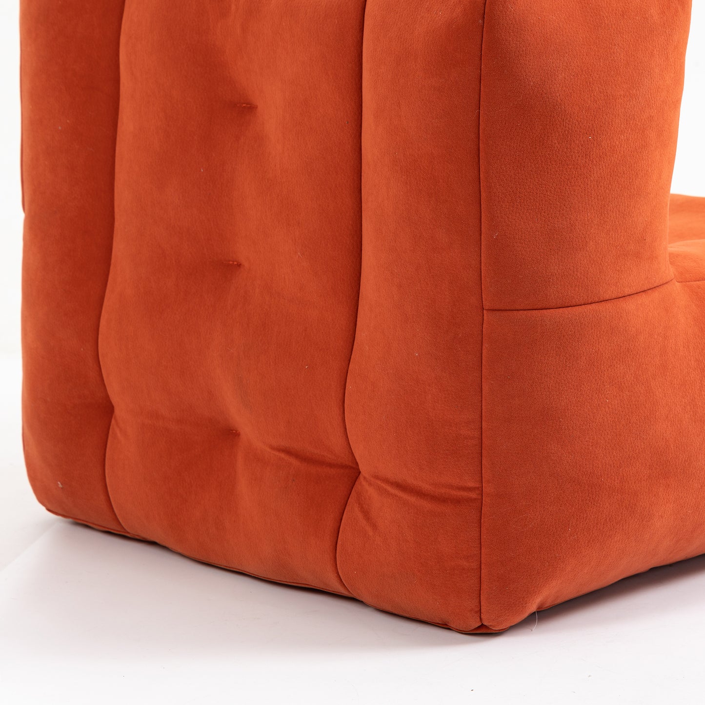 Closeup of a plush terracotta orange modular sofa tufted fabric upholstery with soft curves