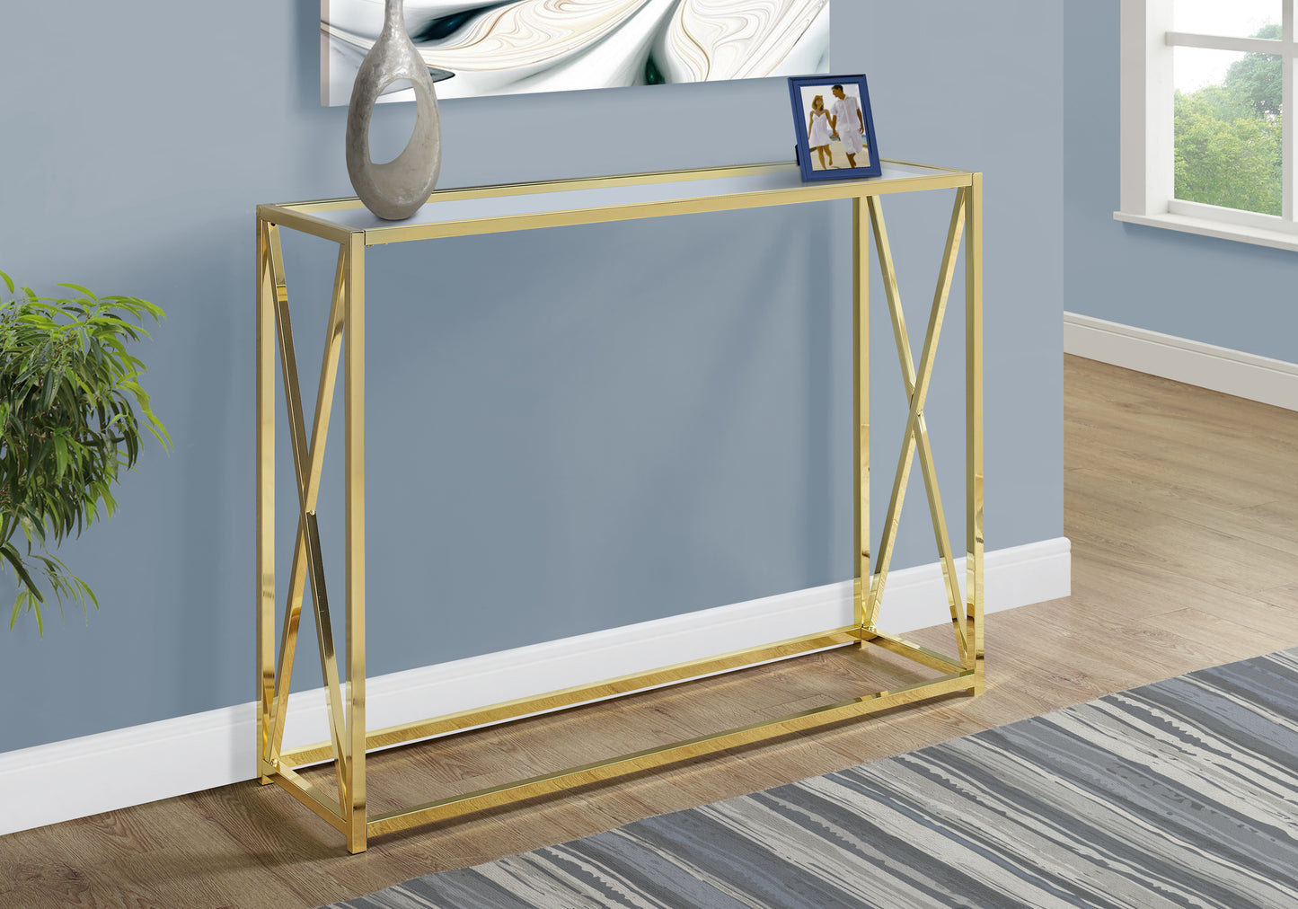 Slim gold console table with clear glass top ideal for entryways