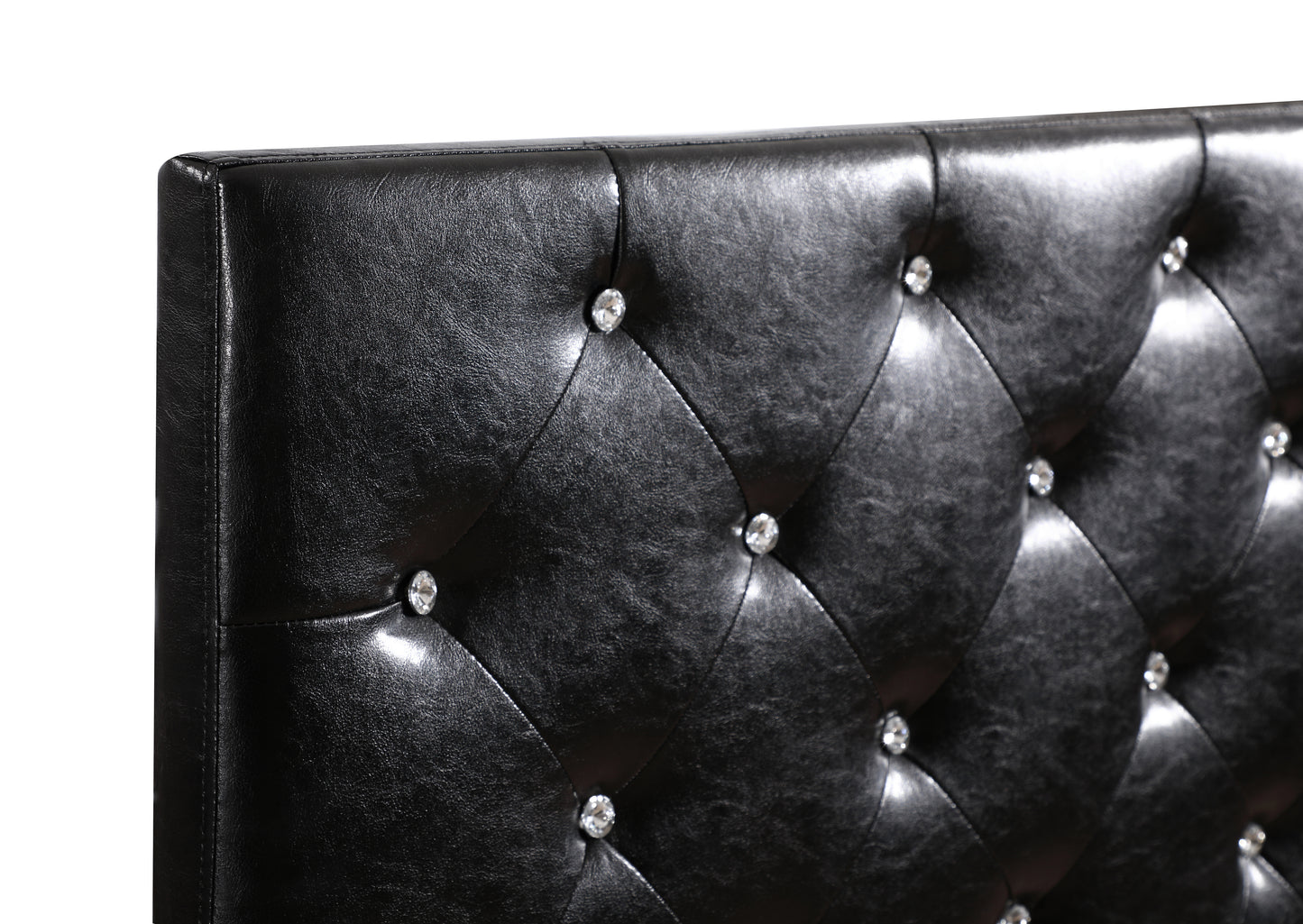 Closeup of a black faux leather tufted headboard with crystal accents