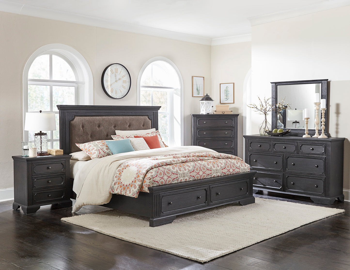 Dark gray upholstered headboard king bed with patterned bedding and matching nightstand