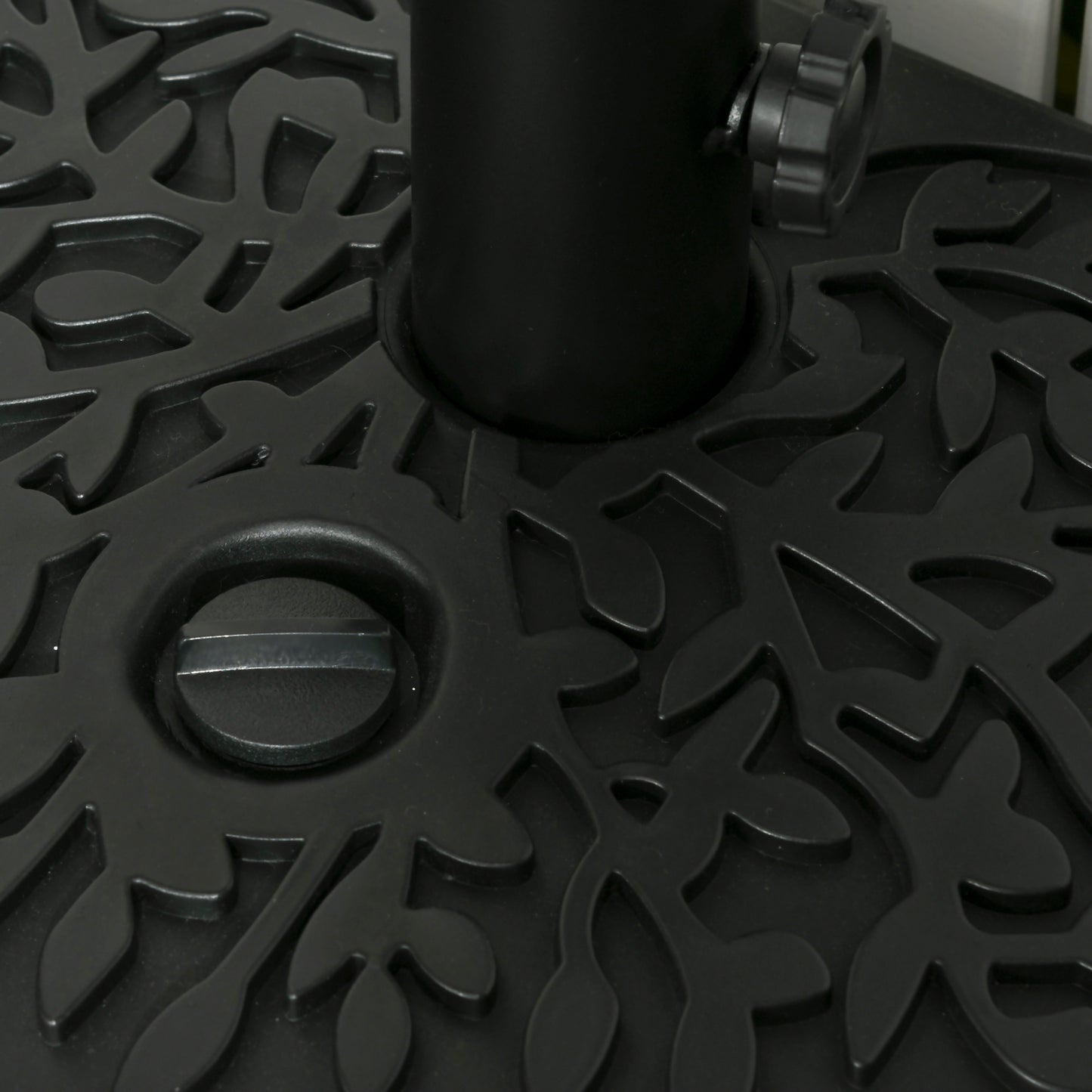 Closeup of a black decorative outdoor umbrella base with leaf pattern