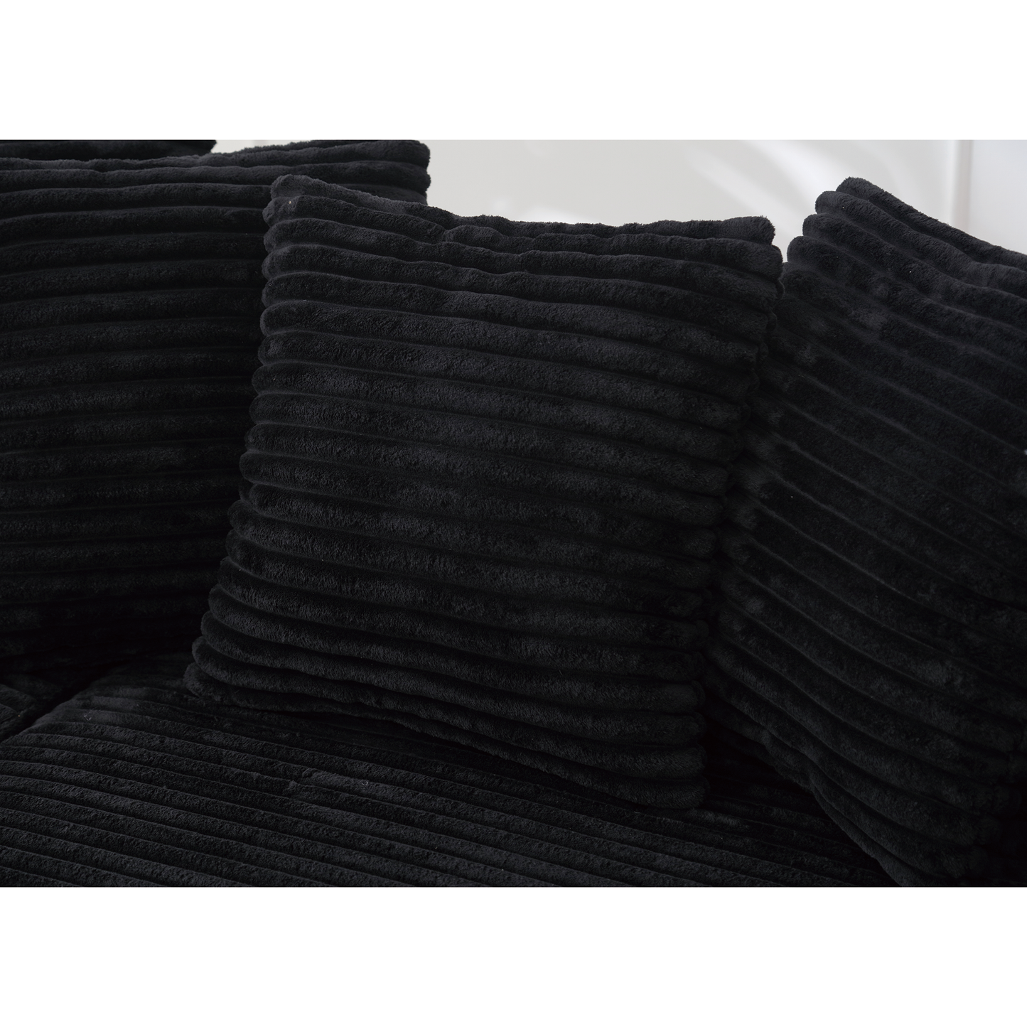 Black corduroy cushion with textured ribbed fabric adds cozy comfort